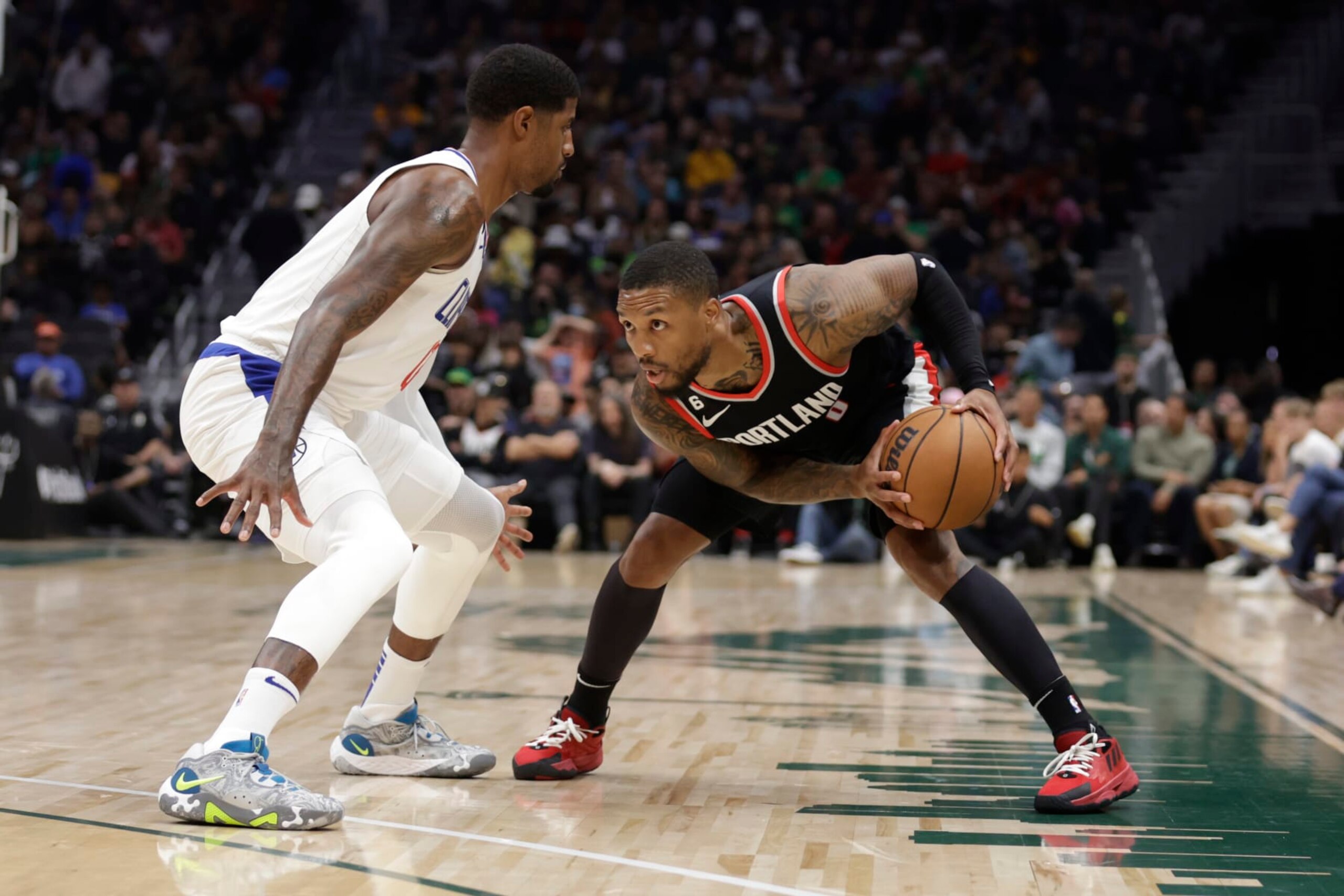 Portland Trailblazers' Damian Lillard works to keep the ball from Los Angeles Clippers' Paul George during the first half of a preseason NBA basketball game, Monday, Oct. 3, 2022, in Seattle. (AP Photo/ John Froschauer)