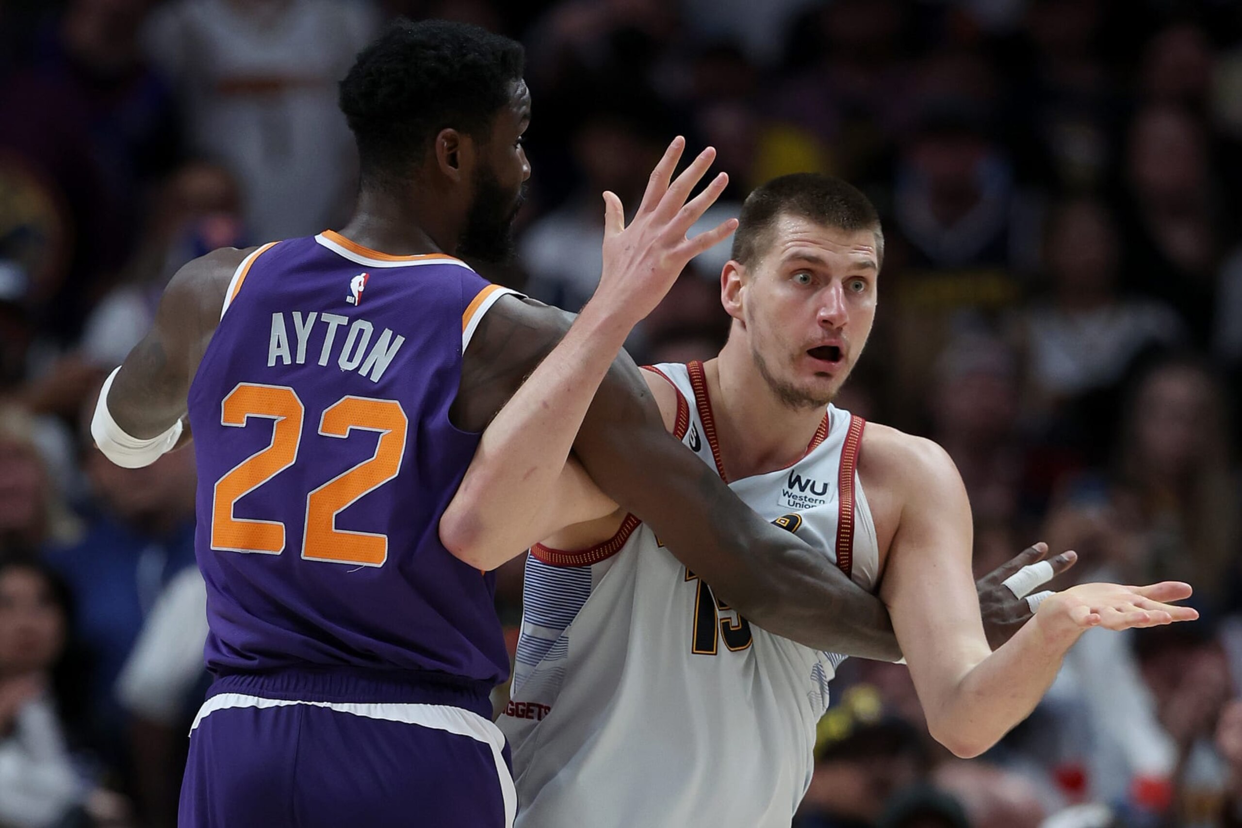 DENVER, COLORADO - MAY 09: Nikola Jokic #15 of the Denver Nuggets looks for a call while being guarded by Deandre Ayton #22 of the Phoenix Suns in the third quarter during Game Five of the NBA Western Conference Semifinals at Ball Arena on May 09, 2023 in Denver, Colorado. NOTE TO USER: User expressly acknowledges and agrees that, by downloading and/or using this photograph, User is consenting to the terms and conditions of the Getty Images License Agreement. (Photo by Matthew Stockman/Getty Images)