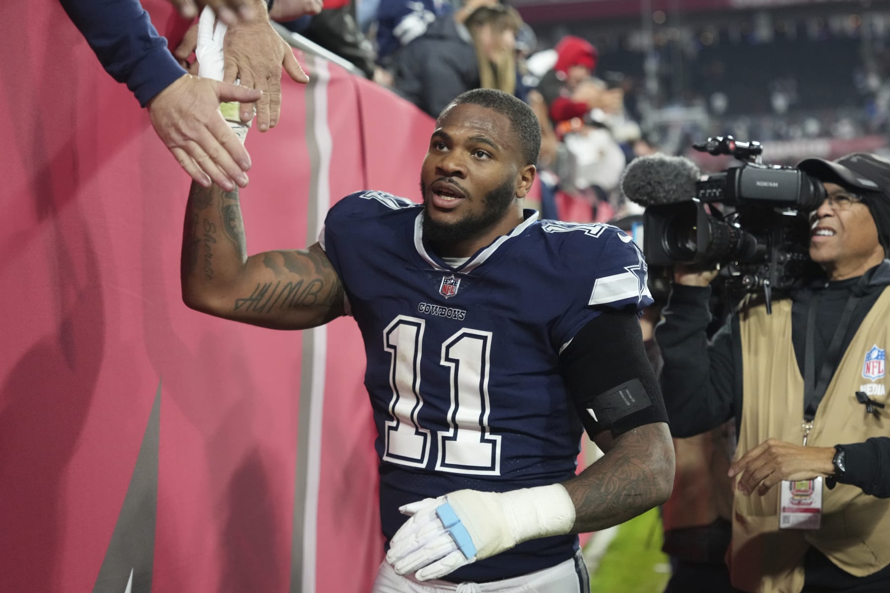 Dallas Cowboys linebacker Micah Parsons (11) gives high fives for fans following an NFL wild-card football game against the Tampa Bay Buccaneers, Monday, Jan. 16, 2023, in Tampa, Fla. (AP Photo/Peter Joneleit)