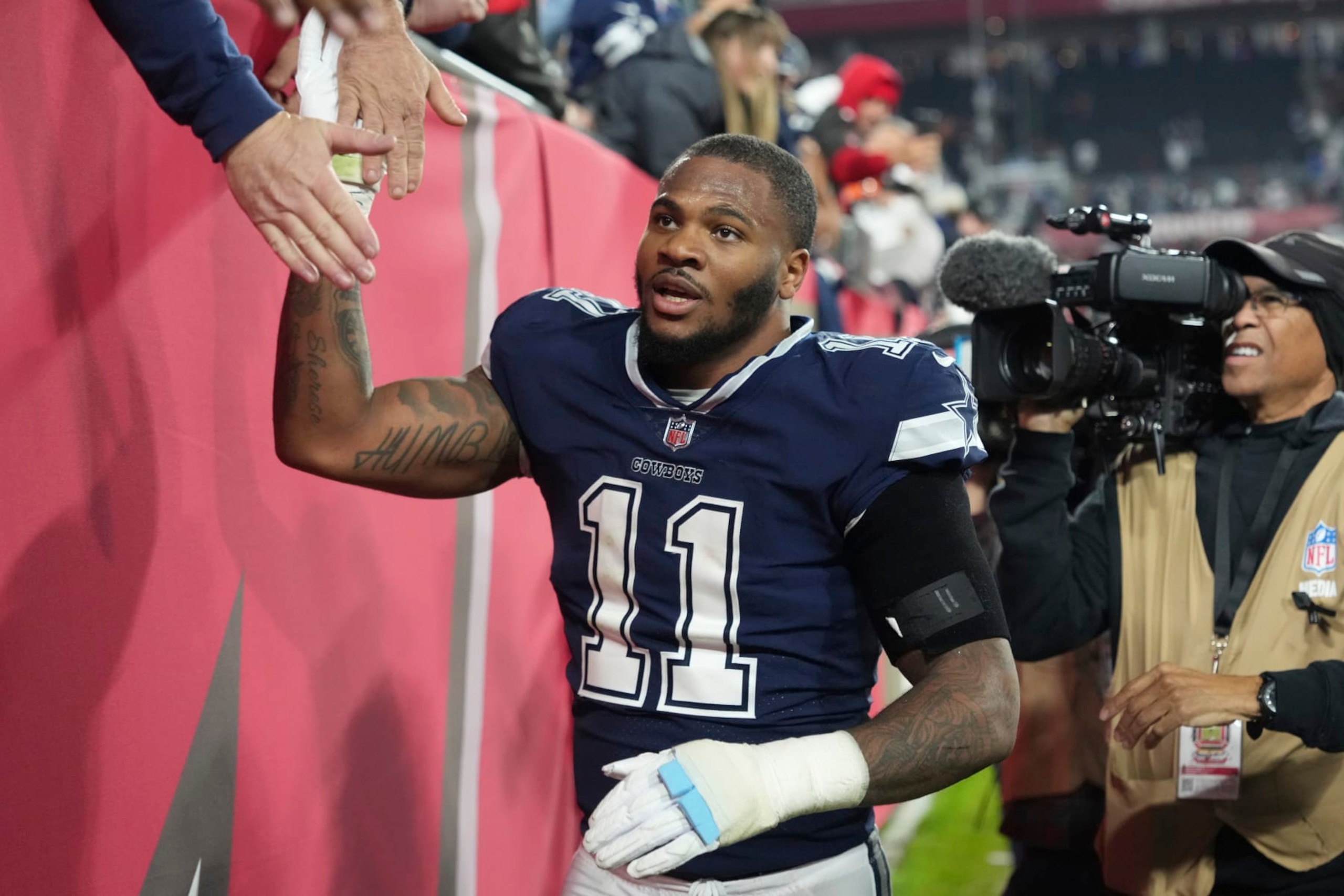 Dallas Cowboys linebacker Micah Parsons (11) gives high fives for fans following an NFL wild-card football game against the Tampa Bay Buccaneers, Monday, Jan. 16, 2023, in Tampa, Fla. (AP Photo/Peter Joneleit)