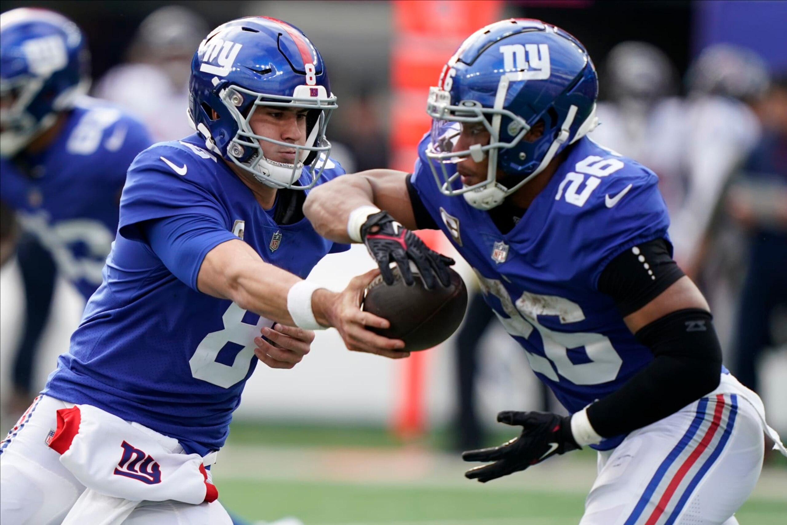 New York Giants quarterback Daniel Jones (8) hands off the ball to New York Giants running back Saquon Barkley (26) during the second quarter of an NFL football game, Sunday, Nov. 13, 2022, in East Rutherford, N.J. (AP Photo/John Minchillo)