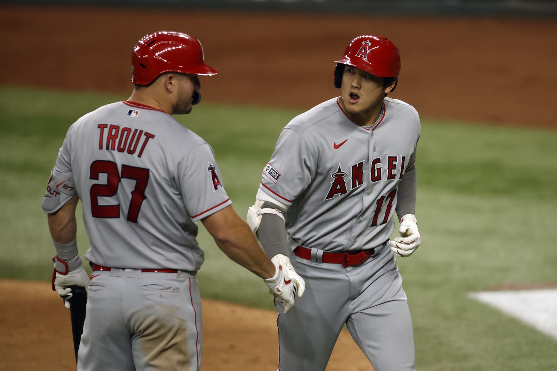 ARLINGTON, TEXAS - JUNE 12: Mike Trout (L) #27 of the Los Angeles Angels congratulates Shohei Ohtani #17 of the Los Angeles Angels after his home run in the seventh inning against the Texas Rangers at Globe Life Field on June 12, 2023 in Arlington, Texas. (Photo by Tim Heitman/Getty Images)