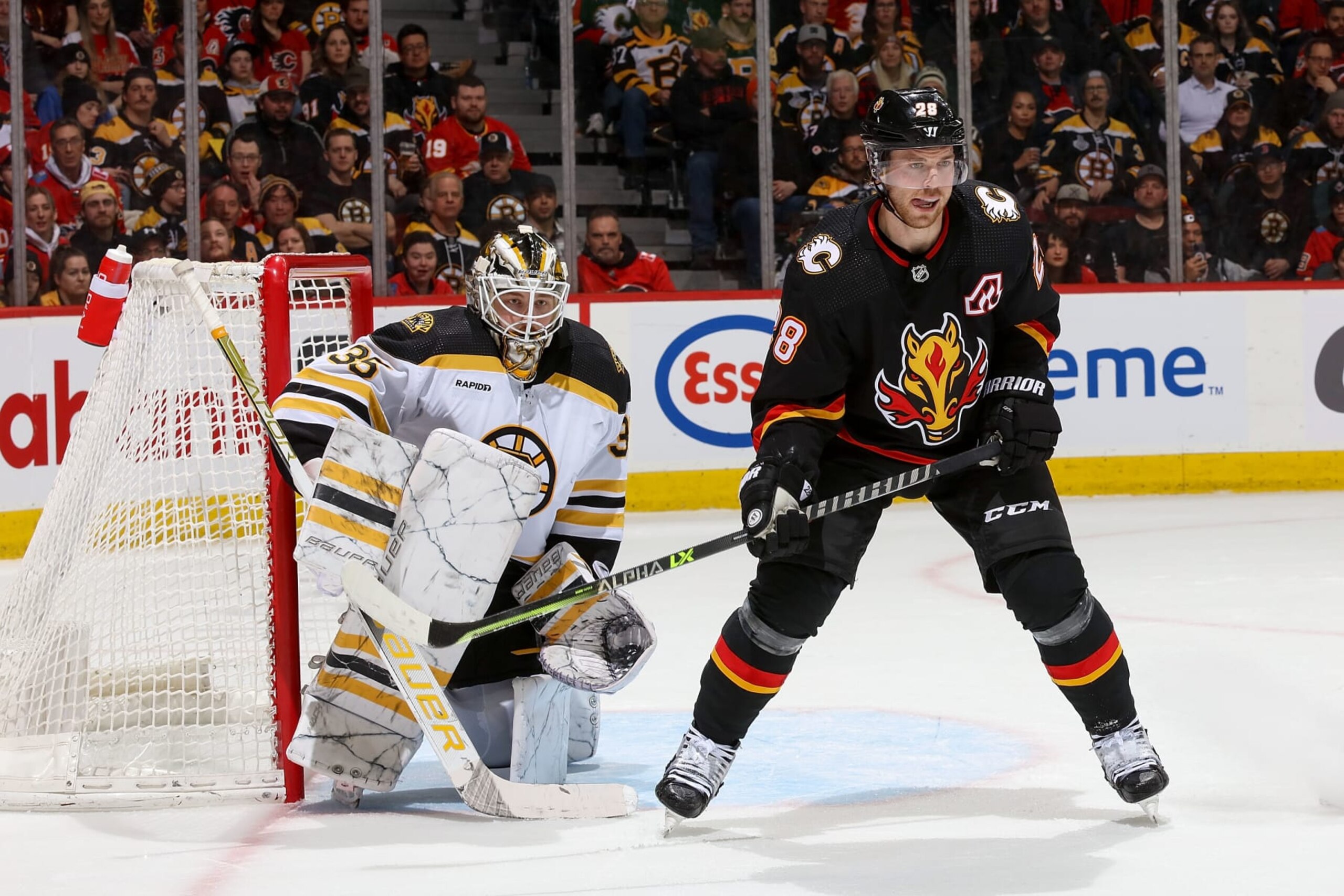 CALGARY, AB - FEBRUARY 28: Elias Lindholm #28 of the Calgary Flames battles in front of the net against Linus Ullmark #35 of the Boston Bruins at Scotiabank Saddledome on February 28, 2023 in Calgary, Alberta, Canada. (Photo by Gerry Thomas/NHLI via Getty Images)