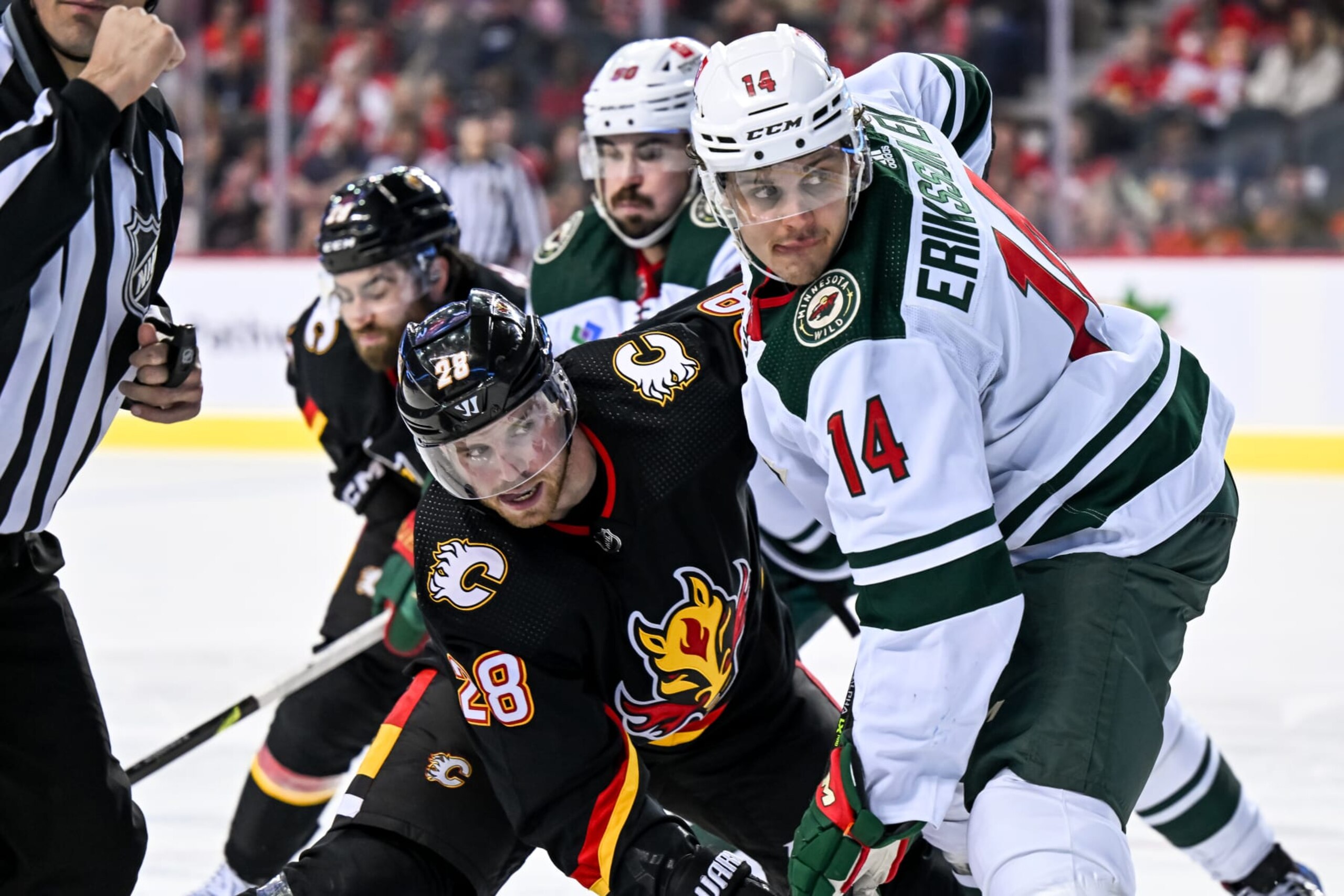 CALGARY, AB - MARCH 04: Calgary Flames Center Elias Lindholm (28) and Minnesota Wild Center Joel Eriksson Ek (14) compete for position during the third period of an NHL game between the Calgary Flames and the Minnesota Wild on March 4, 2023, at the Scotiabank Saddledome in Calgary, AB. (Photo by Brett Holmes/Icon Sportswire via Getty Images)