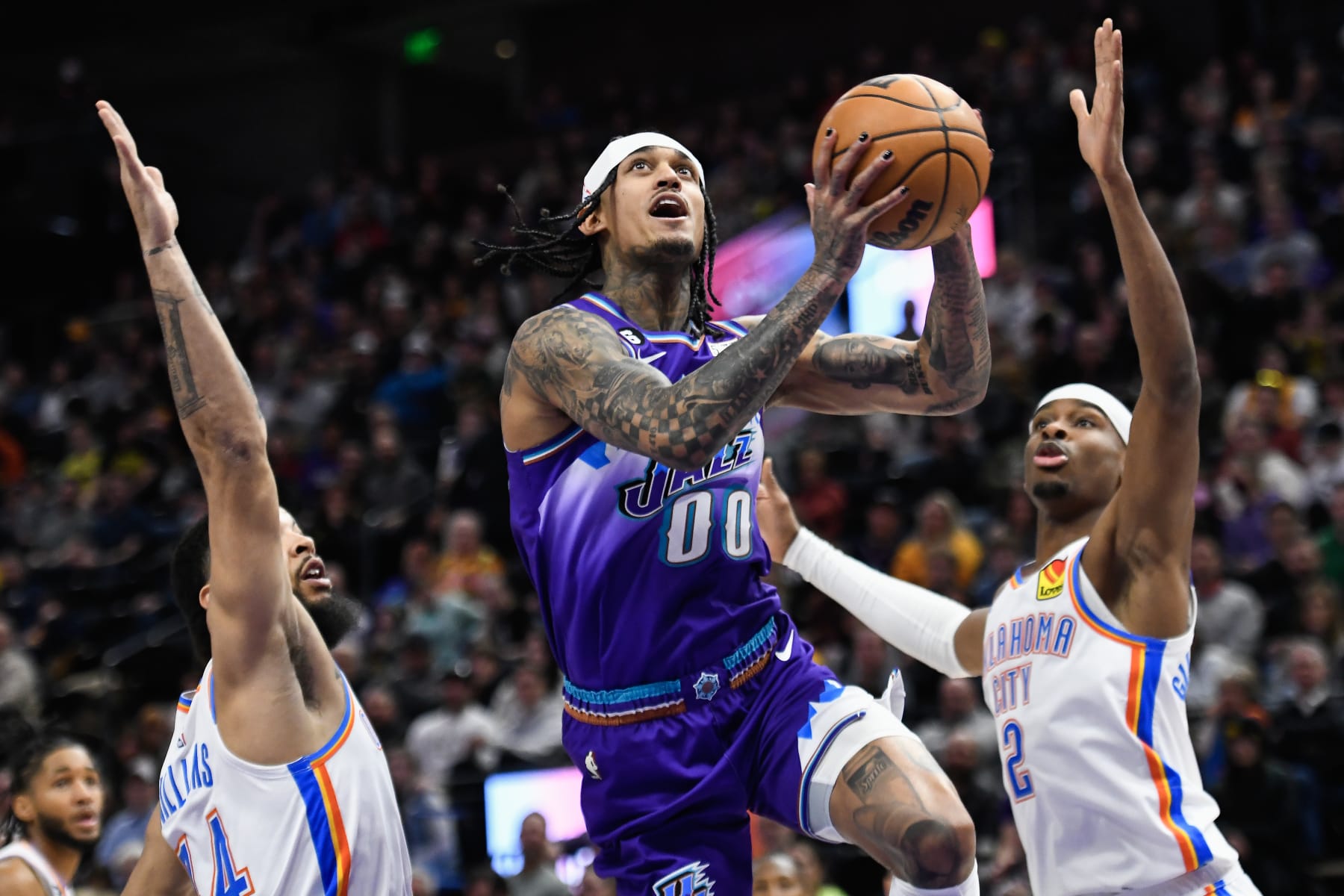 SALT LAKE CITY, UTAH - FEBRUARY 23: Jordan Clarkson #00 of the Utah Jazz shoots between Kenrich Williams #34 and Shai Gilgeous-Alexander #2 of the Oklahoma City Thunder during the first half of a game at Vivint Arena on February 28, 2023 in Salt Lake City, Utah. NOTE TO USER: User expressly acknowledges and agrees that, by downloading and or using this photograph, User is consenting to the terms and conditions of the Getty Images License Agreement. (Photo by Alex Goodlett/Getty Images)