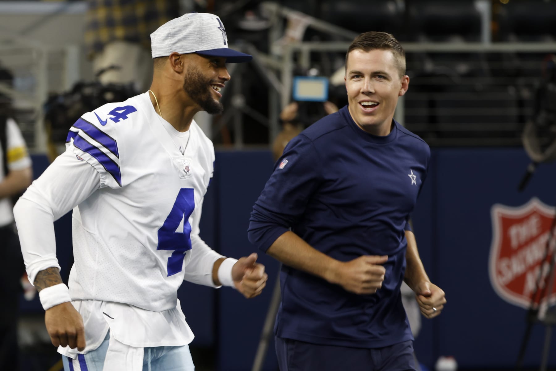 Dallas Cowboys quarterback Dak Prescott (4) and offensive coordinator Kellen Moore take the field before the game against the Houston Texans in a preseason NFL football game in Arlington, Texas, Saturday, Aug. 21, 2021. (AP Photo/Ron Jenkins)