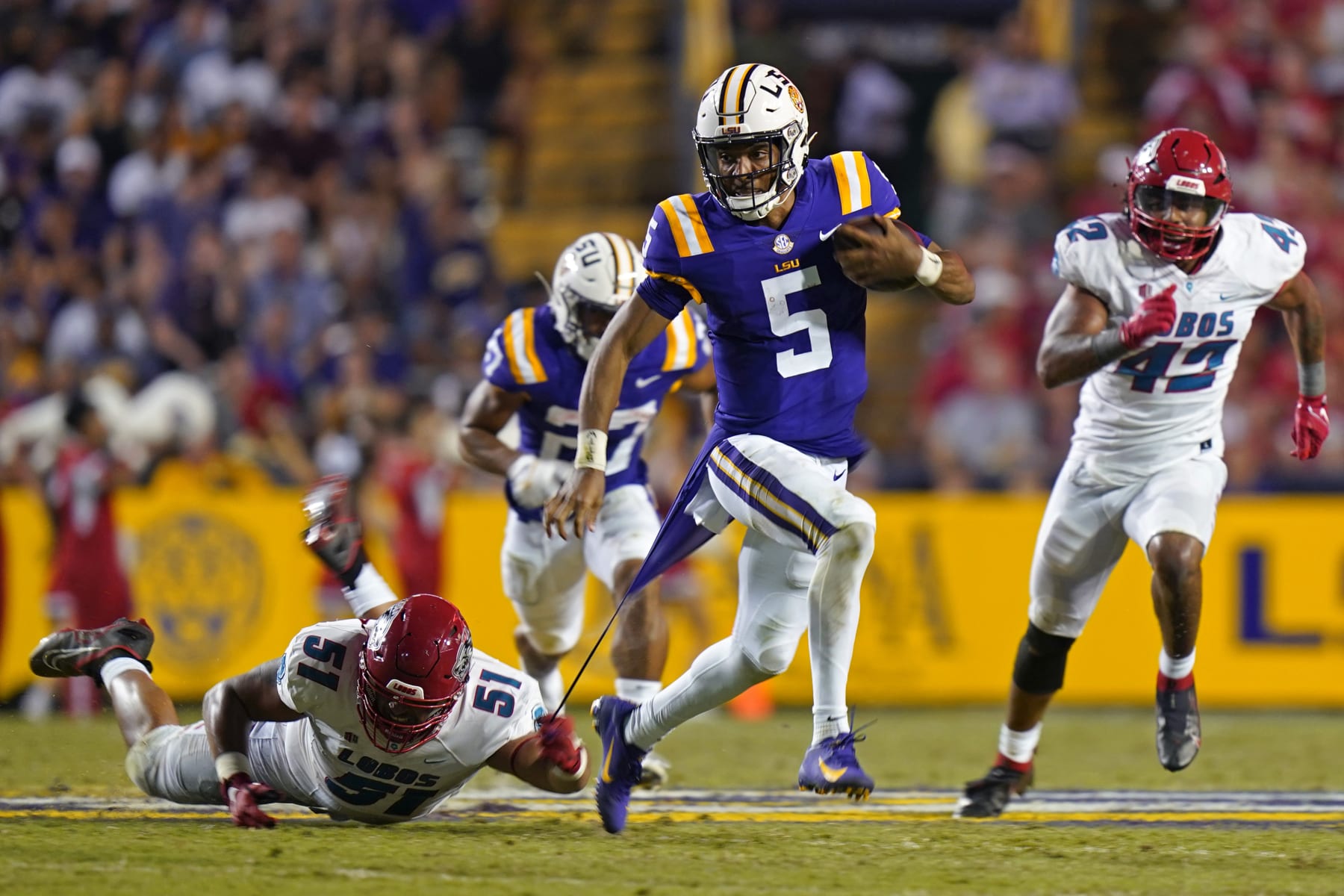 LSU quarterback Jayden Daniels (5) carries against New Mexico defensive end Bryce Santana (51) in the second half of an NCAA college football game in Baton Rouge, La., Saturday, Sept. 24, 2022. LSU won 38-0. (AP Photo/Gerald Herbert)