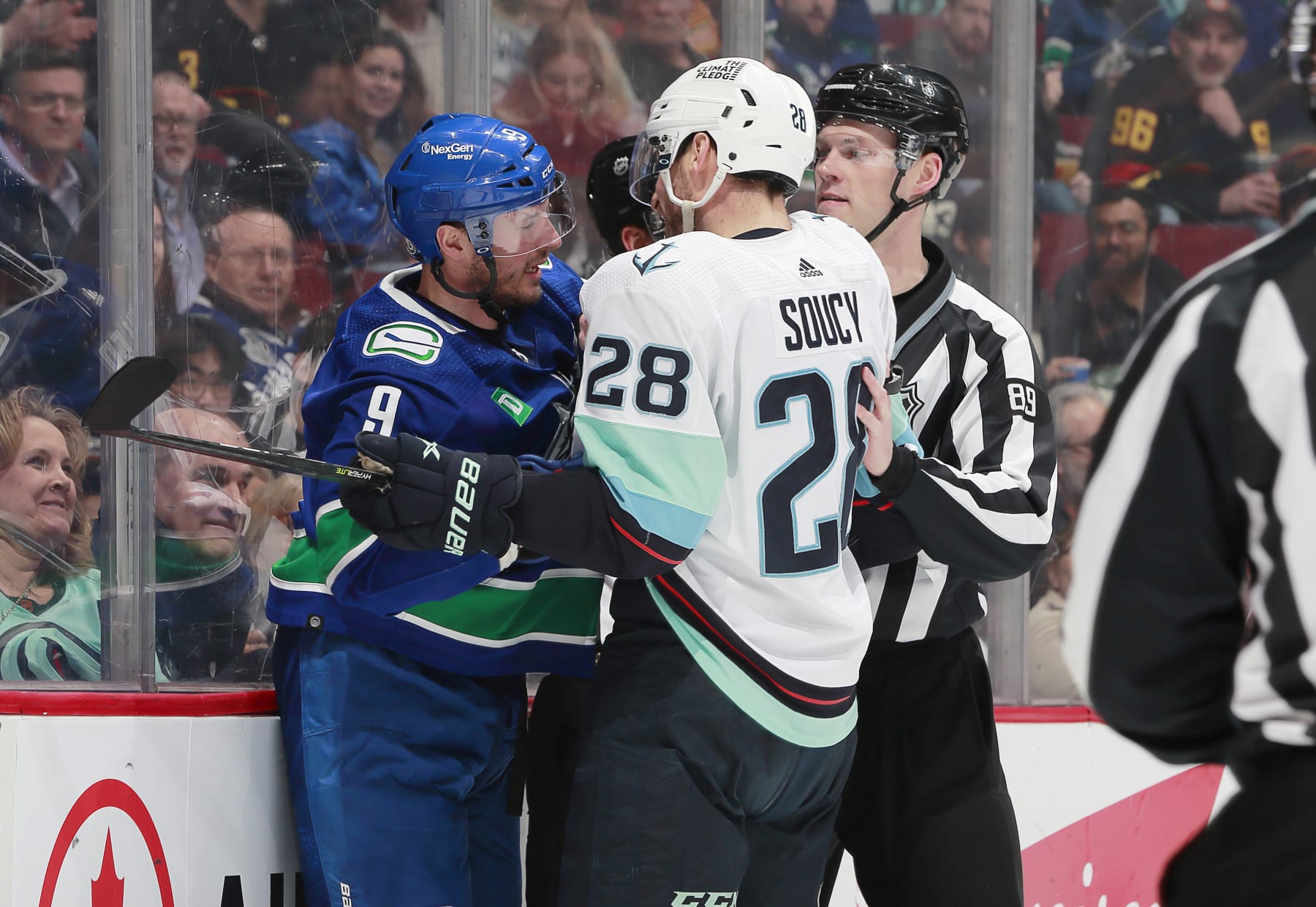 VANCOUVER, CANADA - APRIL 4: J.T. Miller #9 of the Vancouver Canucks and Carson Soucy #28 of the Seattle Kraken share words during the first period of their NHL game at Rogers Arena April 4, 2023 in Vancouver, British Columbia, Canada.  (Photo by Jeff Vinnick/NHLI via Getty Images)