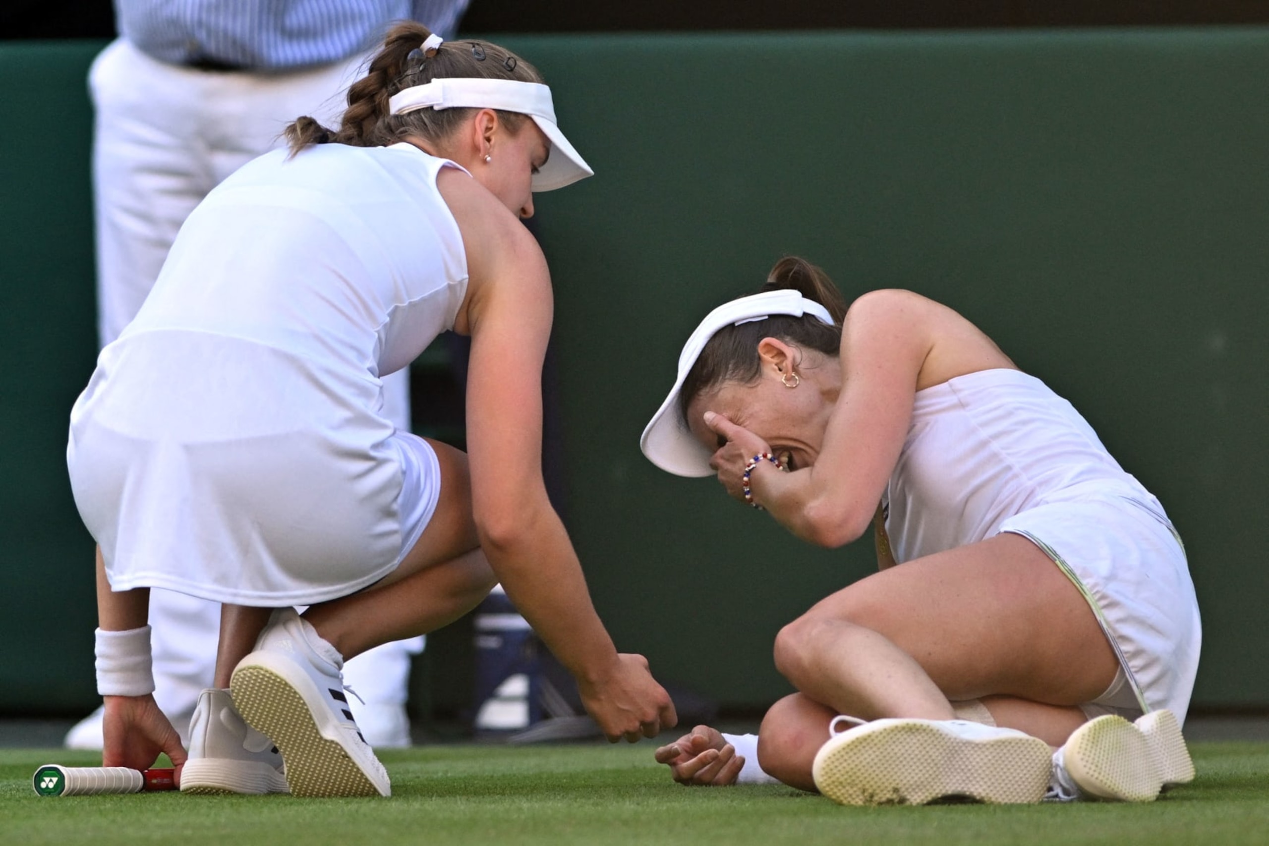 TOPSHOT - Kazakhstan's Elena Rybakina (L) checks on France's Alize Cornet after resulting injured during their women's singles tennis match on the fourth day of the 2023 Wimbledon Championships at The All England Tennis Club in Wimbledon, southwest London, on July 6, 2023. (Photo by Glyn KIRK / AFP) / RESTRICTED TO EDITORIAL USE (Photo by GLYN KIRK/AFP via Getty Images)