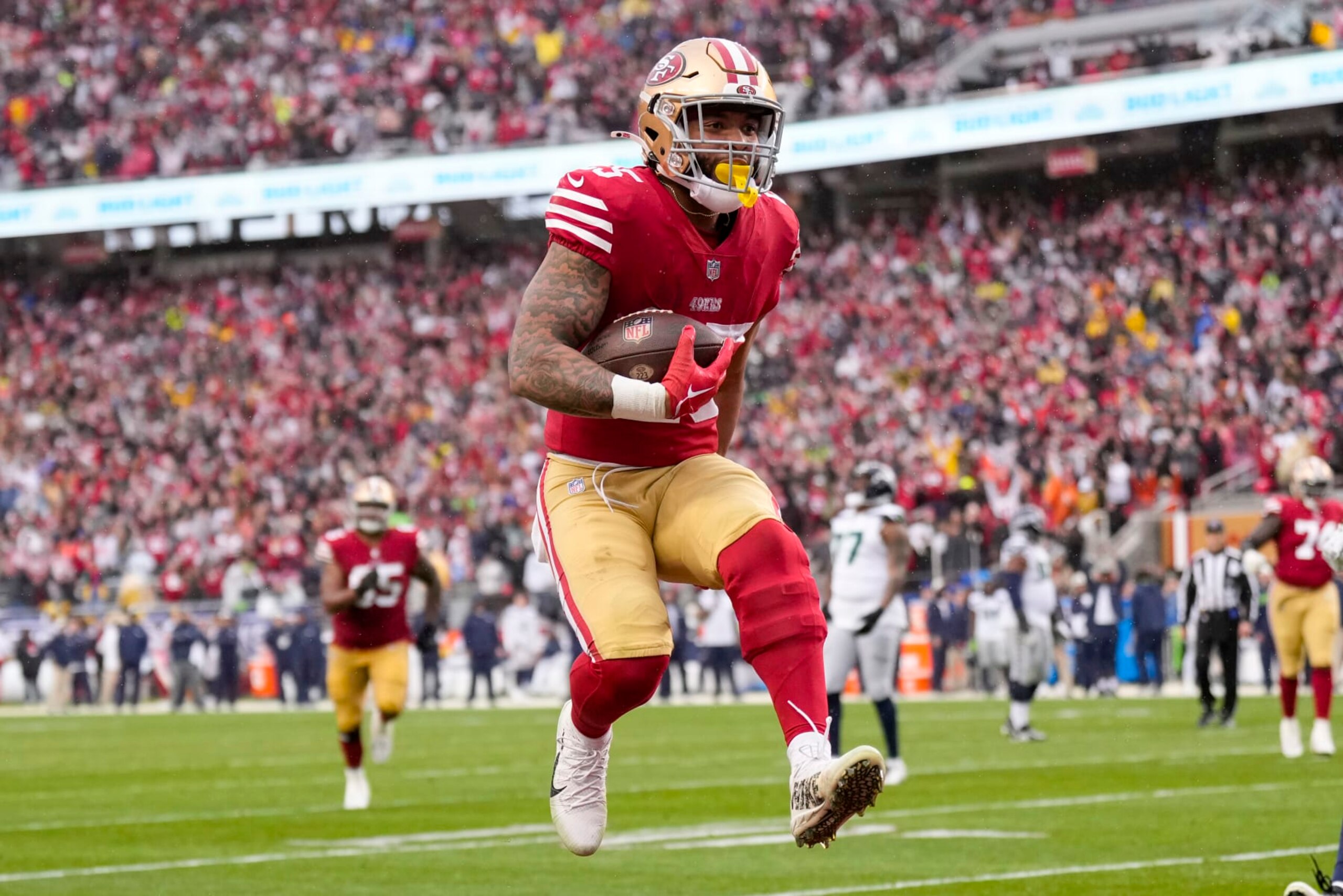 SANTA CLARA, CALIFORNIA - JANUARY 14: Elijah Mitchell #25 of the San Francisco 49ers scores a 7 yard touchdown against the Seattle Seahawks during the fourth quarter in the NFC Wild Card playoff game at Levi's Stadium on January 14, 2023 in Santa Clara, California. (Photo by Thearon W. Henderson/Getty Images)