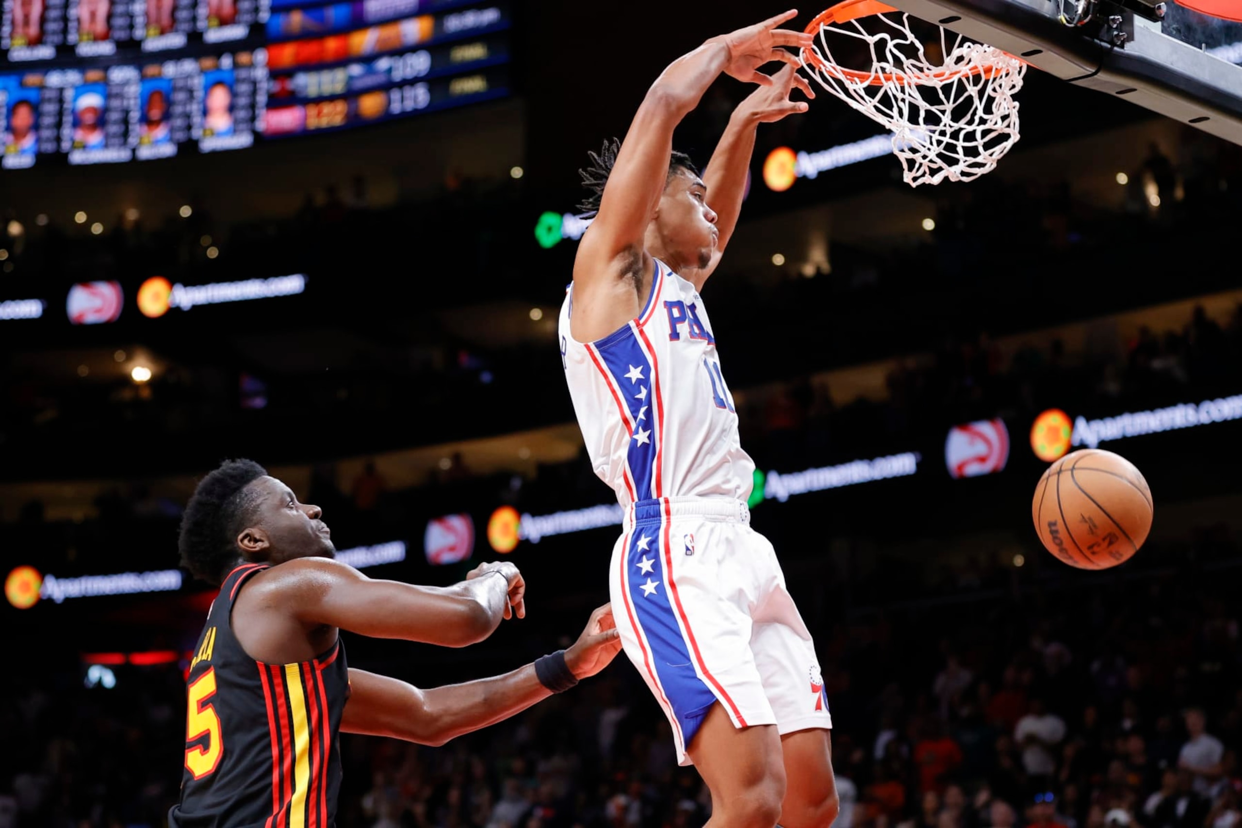 Philadelphia 76ers guard Jaden Springer, right, dunks next to Atlanta Hawks center Clint Capela during the second half of an NBA basketball game Friday, April 7, 2023, in Atlanta. (AP Photo/Alex Slitz)