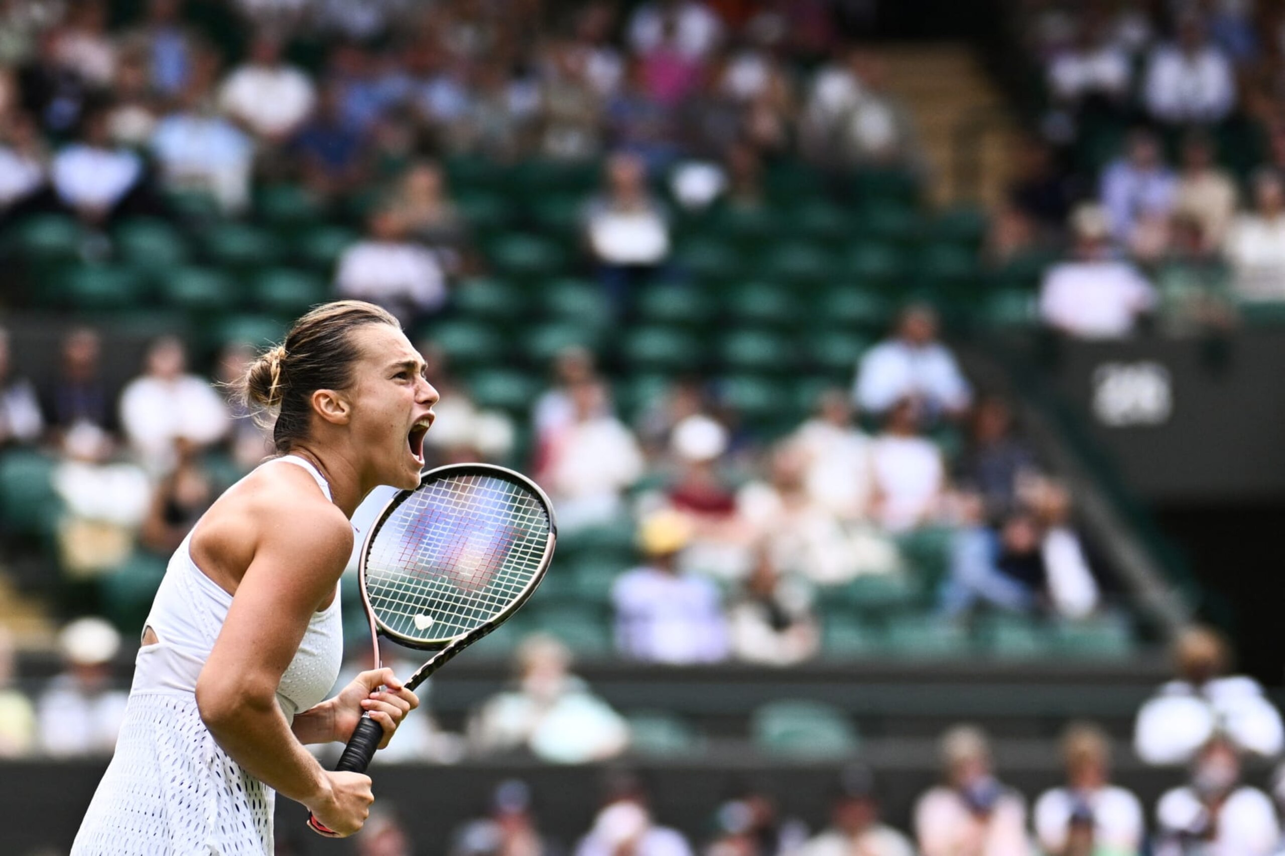 TOPSHOT - Belarus's Aryna Sabalenka celebrates winning a point against Russia's Ekaterina Alexandrova during their women's singles tennis match on the eighth day of the 2023 Wimbledon Championships at The All England Tennis Club in Wimbledon, southwest London, on July 10, 2023. (Photo by SEBASTIEN BOZON / AFP) / RESTRICTED TO EDITORIAL USE (Photo by SEBASTIEN BOZON/AFP via Getty Images)