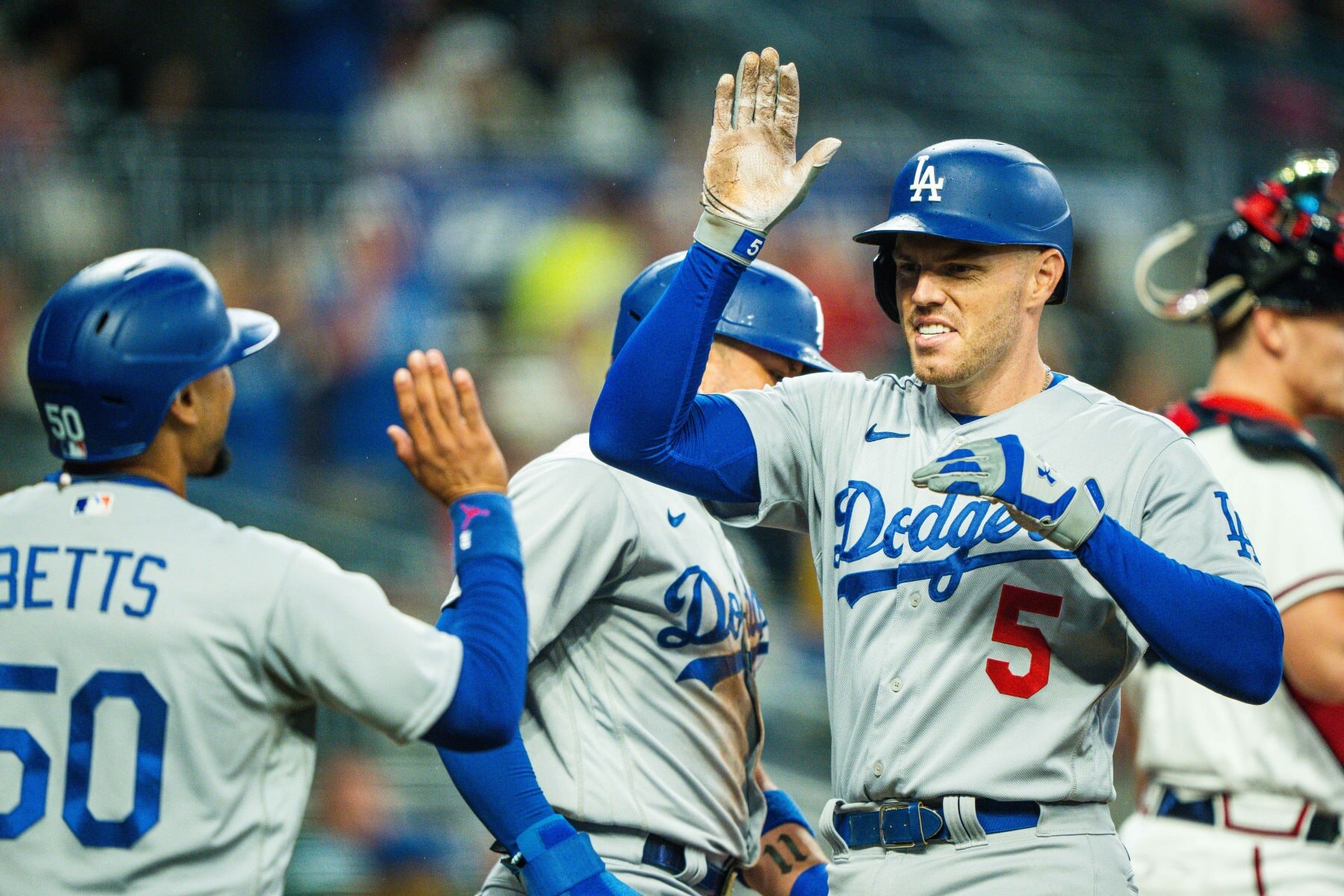 ATLANTA, GA - MAY 22: Freddie Freeman #5 of the Los Angeles Dodgers high fives Mookie Betts #50 after scoring during the game against the Atlanta Braves at Truist Park on May 22, 2023 in Atlanta, Georgia. (Photo by Kevin D. Liles/Atlanta Braves/Getty Images)
