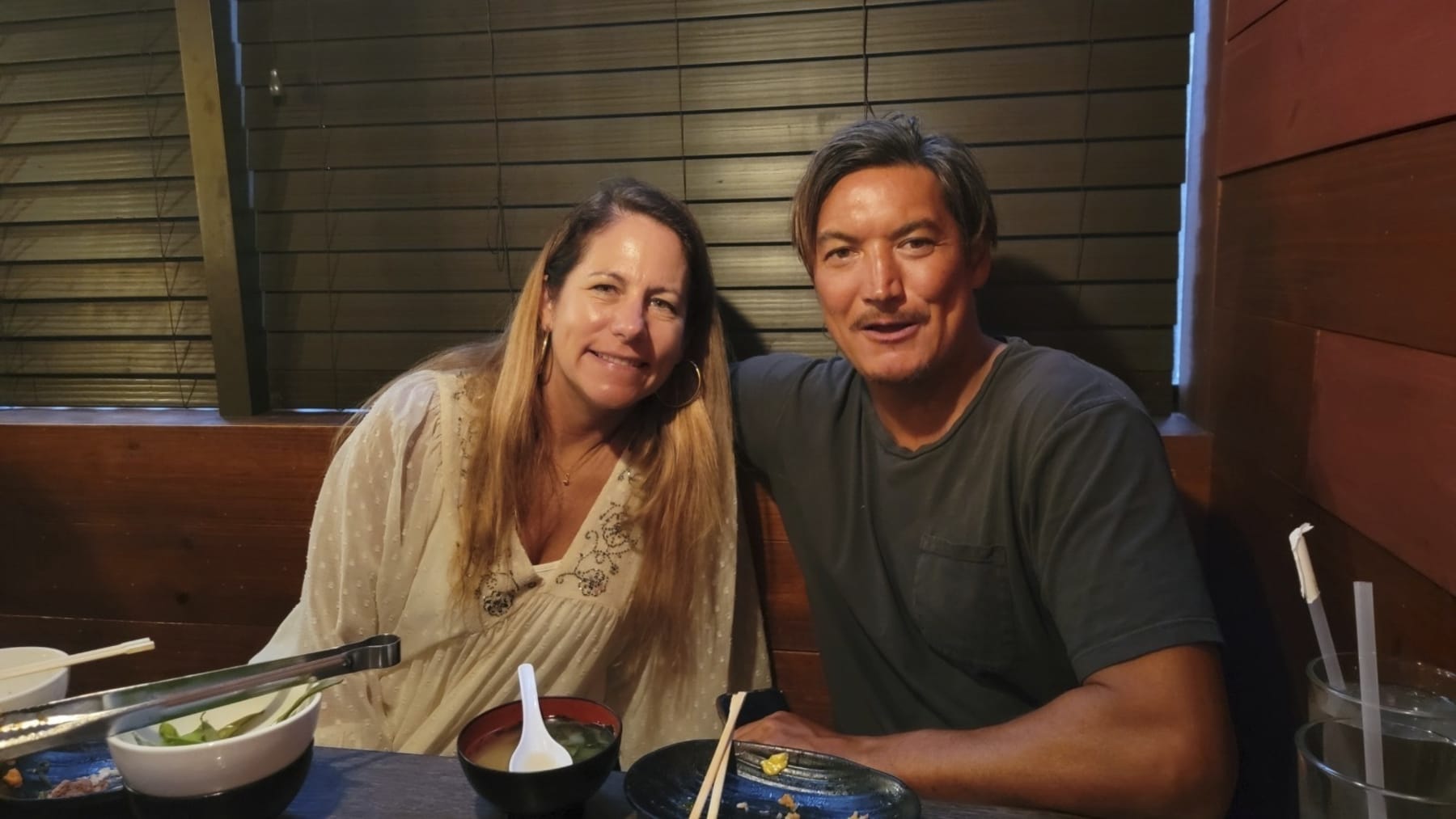 This June 2022 photo provided by Dr. John Jones shows Mikala Jones, right, and his wife Emma Brereton in New York. Mikala Jones, a Hawaii surfer known for shooting awe-inspiring photos and videos from the inside of barreling waves, has died at the age of 44 after a surfing accident in Indonesia. (Dr. John Jones via AP)