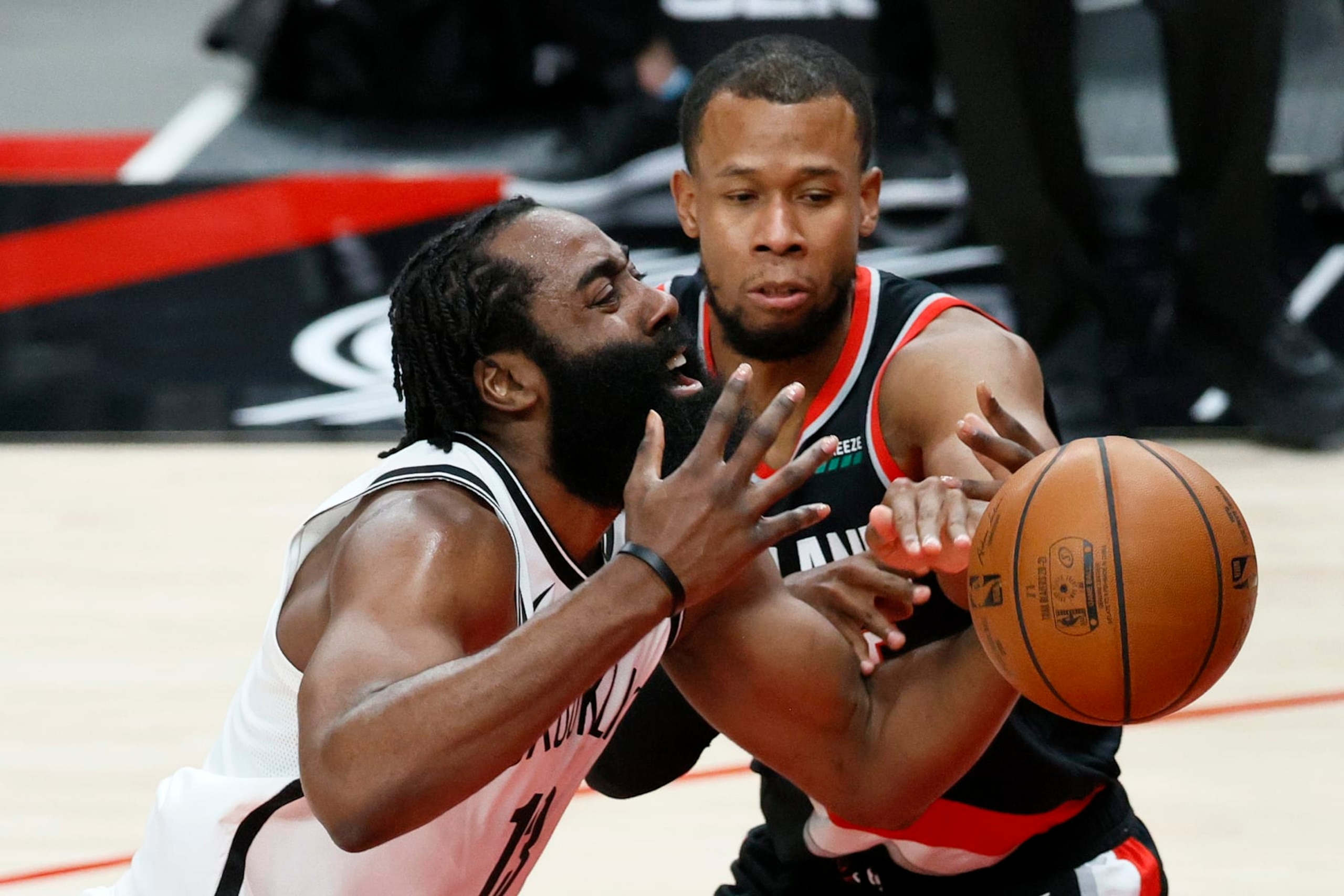 PORTLAND, OREGON - MARCH 23: James Harden #13 of the Brooklyn Nets loses control of the ball while defended by Rodney Hood #5 of the Portland Trail Blazers during the first quarter at Moda Center on March 23, 2021 in Portland, Oregon. NOTE TO USER: User expressly acknowledges and agrees that, by downloading and or using this photograph, User is consenting to the terms and conditions of the Getty Images License Agreement. (Photo by Steph Chambers/Getty Images)