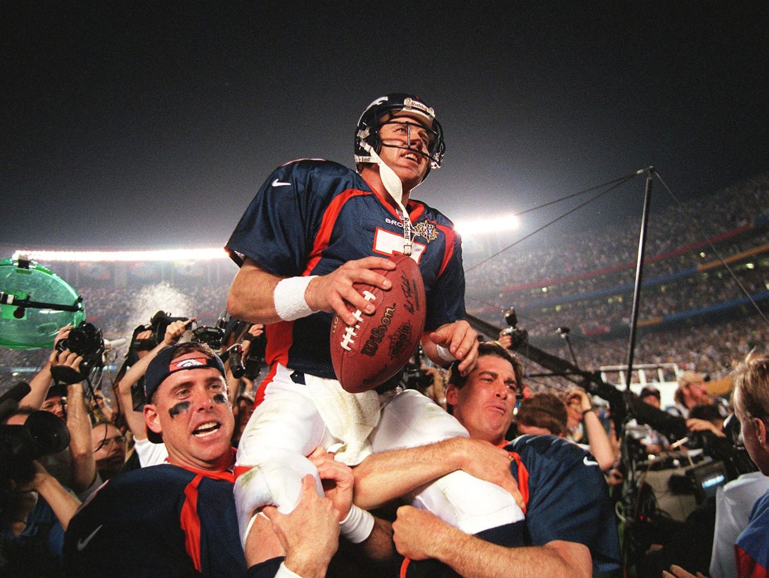 Denver Broncos quarterback John Elway (C) is carried by teammates Ed McCaffrey (L) and Bubby Brister (R) after the Broncos defeated the  Green Bay Packers 31-24 to win Super Bowl XXXII in San Diego, CA 25 January.       AFP PHOTO/Timothy A. CLARY (Photo by Timothy A. CLARY / AFP) (Photo by TIMOTHY A. CLARY/AFP via Getty Images)