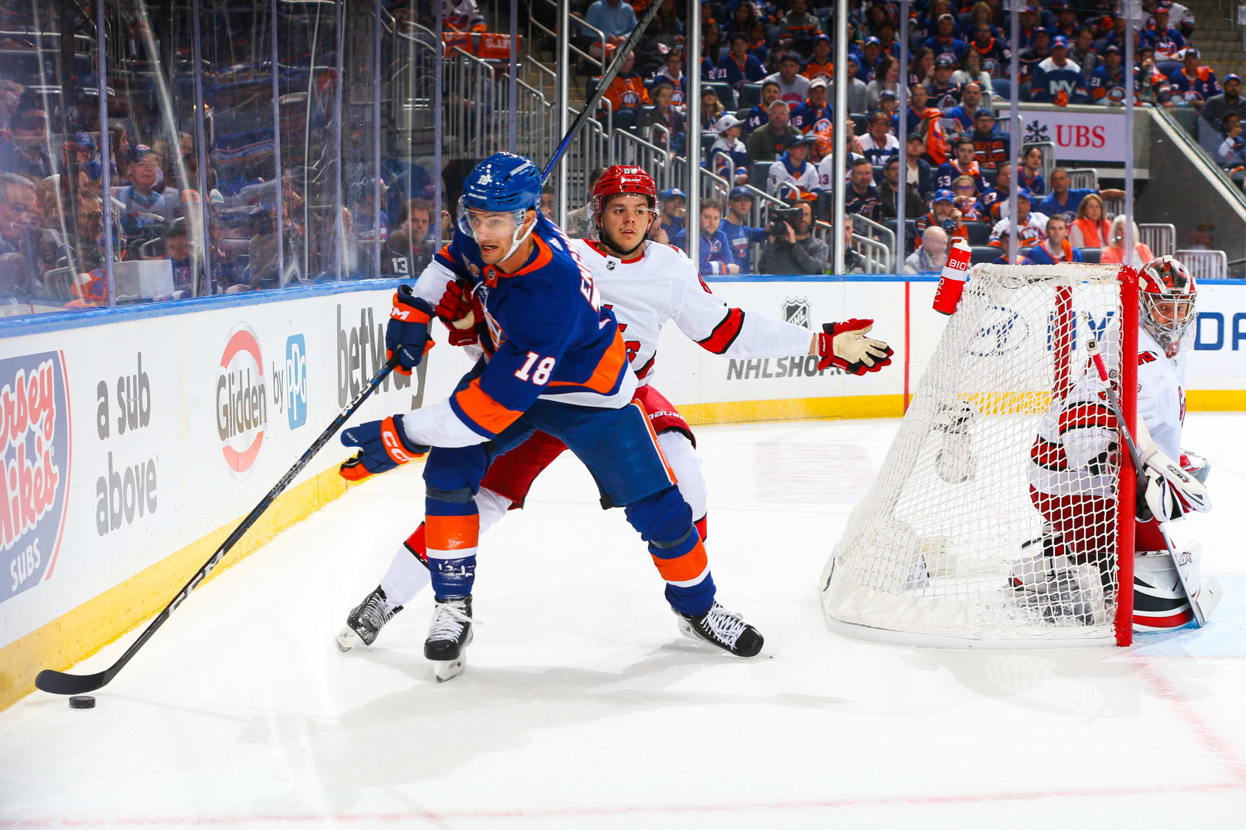 ELMONT, NEW YORK - APRIL 23:  Pierre Engvall #18 of the New York Islanders skates with the puck against Jesperi Kotkaniemi #82 of the Carolina Hurricanes in Game Four of the First Round of the 2023 Stanley Cup Playoffs at UBS Arena on April 23, 2023 in Elmont, New York. (Photo by Mike Stobe/NHLI via Getty Images)