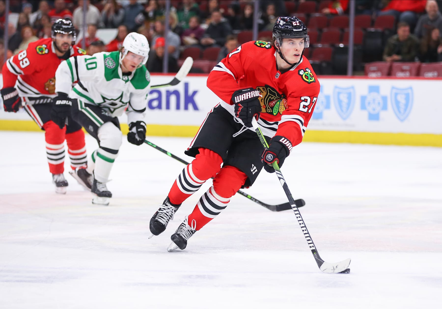 CHICAGO, IL - MARCH 28: Chicago Blackhawks left wing Lukas Reichel (27) brings the puck up ice during a game between the Dallas Stars and the Chicago Blackhawks on March 28, 2022 at the United Center in Chicago, IL. (Photo by Melissa Tamez/Icon Sportswire via Getty Images)