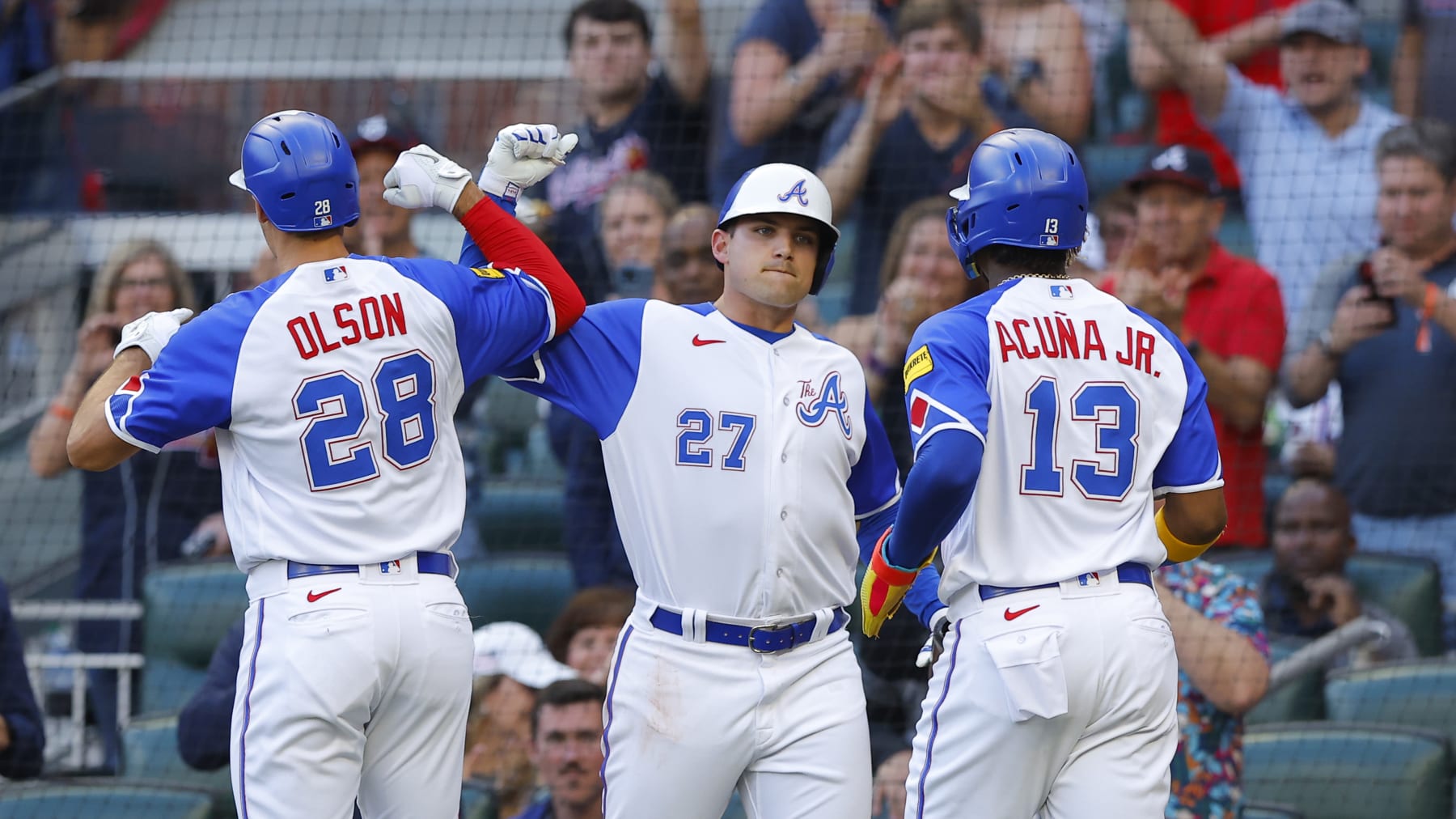 ATLANTA, GA - MAY 20: Austin Riley #27 celebrates as Matt Olson #28 and Ronald Acuna Jr. #13 of the Atlanta Braves crosses the plate following Olsons two run home run during the first inning against the Seattle Mariners at Truist Park on May 20, 2023 in Atlanta, Georgia. (Photo by Todd Kirkland/Getty Images)