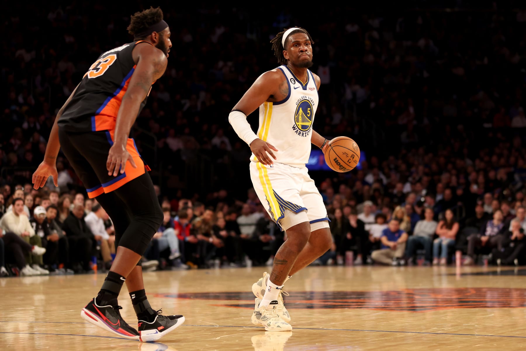 NEW YORK, NEW YORK - DECEMBER 20: Kevon Looney #5 of the Golden State Warriors dribbles against Mitchell Robinson #23 of the New York Knicks during the second quarter of the game at Madison Square Garden on December 20, 2022 in New York City. NOTE TO USER: User expressly acknowledges and agrees that, by downloading and/or using this photograph, User is consenting to the terms and conditions of the Getty Images License Agreement. (Photo by Sarah Stier/Getty Images)