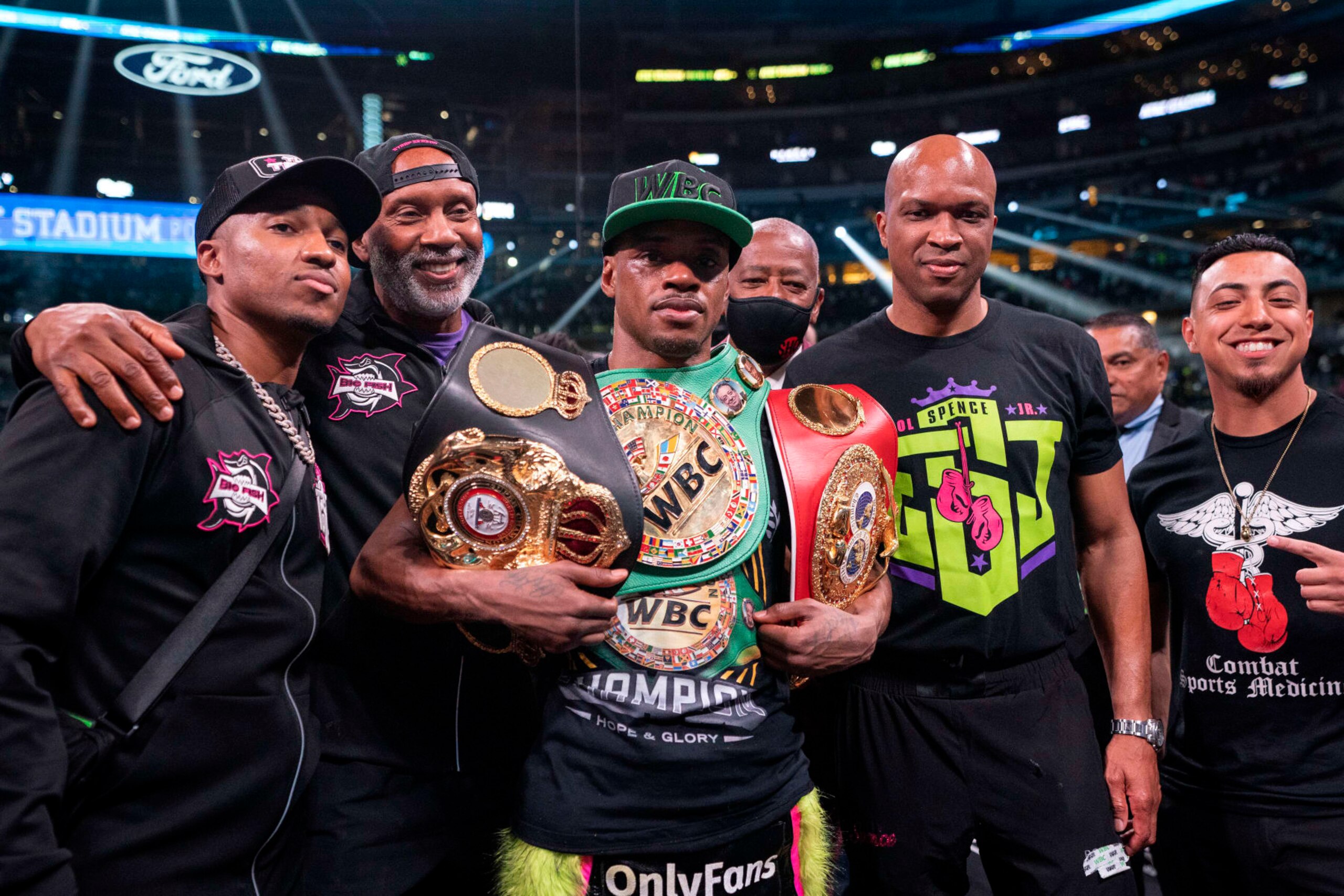 Errol Spence Jr. poses with his team after beating Yordenis Ugas, from Cuba, in a welterweight championship boxing match Saturday, April 16, 2022, in Arlington, Texas. (AP Photo/Jeffrey McWhorter)