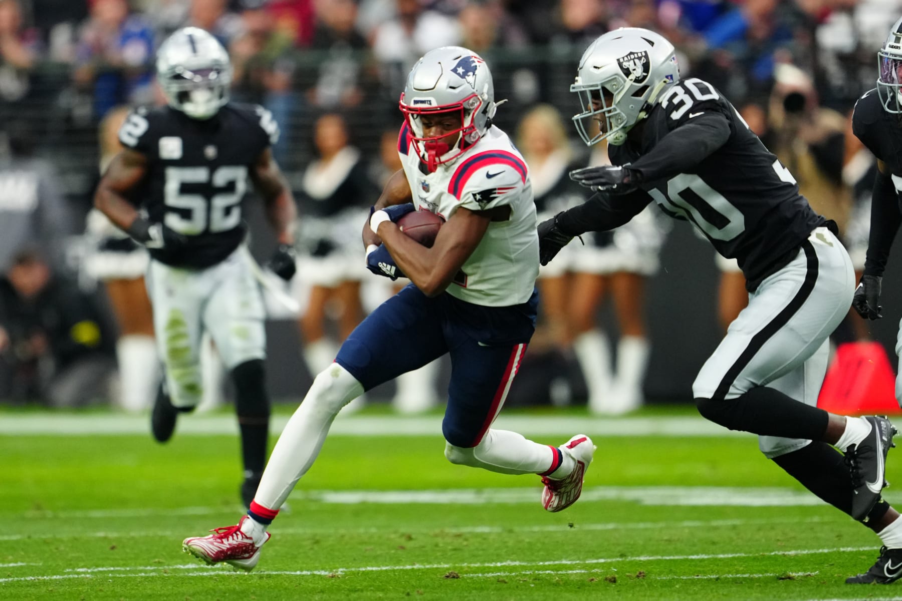 LAS VEGAS, NEVADA - DECEMBER 18: Tyquan Thornton #11 of the New England Patriots runs with the ball as Duron Harmon #30 of the Las Vegas Raiders defends during the first half at Allegiant Stadium on December 18, 2022 in Las Vegas, Nevada. (Photo by Jeff Bottari/Getty Images)