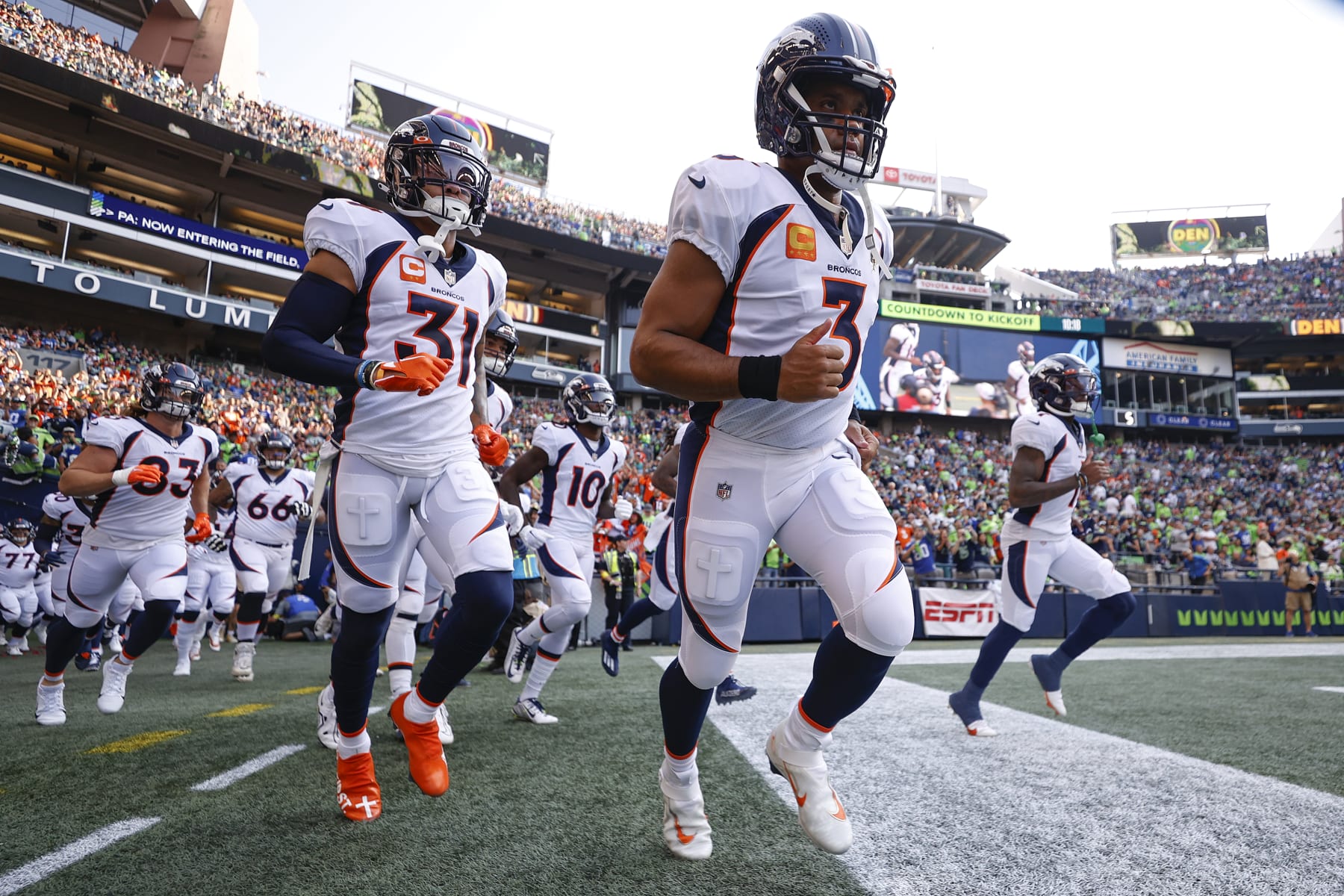 SEATTLE, WASHINGTON - SEPTEMBER 12: Justin Simmons #31 (L) and Russell Wilson #3 of the Denver Broncos (C) enter the field before playing against the Seattle Seahawks at Lumen Field on September 12, 2022 in Seattle, Washington. (Photo by Steph Chambers/Getty Images)