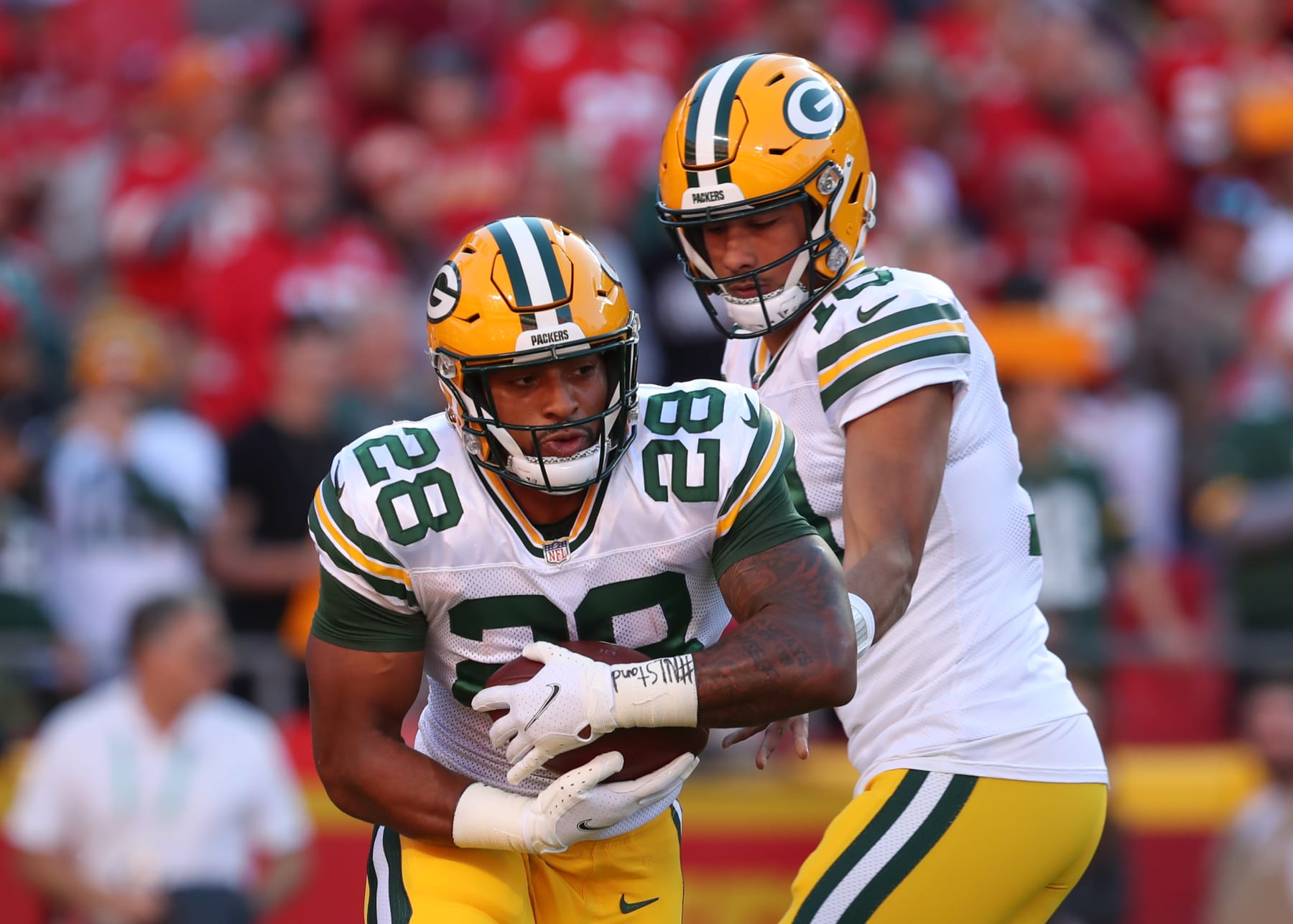 KANSAS CITY, MO - NOVEMBER 07: Green Bay Packers running back A.J. Dillon (28) takes a handoff from quarterback Jordan Love (10) in warmups before an NFL game between the Green Bay Packers and Kansas City Chiefs on Nov 7, 2021 at GEHA Field at Arrowhead Stadium in Kansas City, MO. (Photo by Scott Winters/Icon Sportswire via Getty Images)