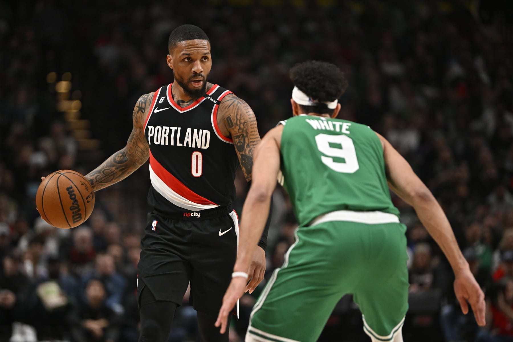 PORTLAND, OREGON - MARCH 17: Damian Lillard #0 of the Portland Trail Blazers dribbles against Derrick White #9 of the Boston Celtics during the second quarter at the Moda Center on March 17, 2023 in Portland, Oregon. NOTE TO USER: User expressly acknowledges and agrees that, by downloading and or using this photograph, User is consenting to the terms and conditions of the Getty Images License Agreement. (Photo by Alika Jenner/Getty Images)