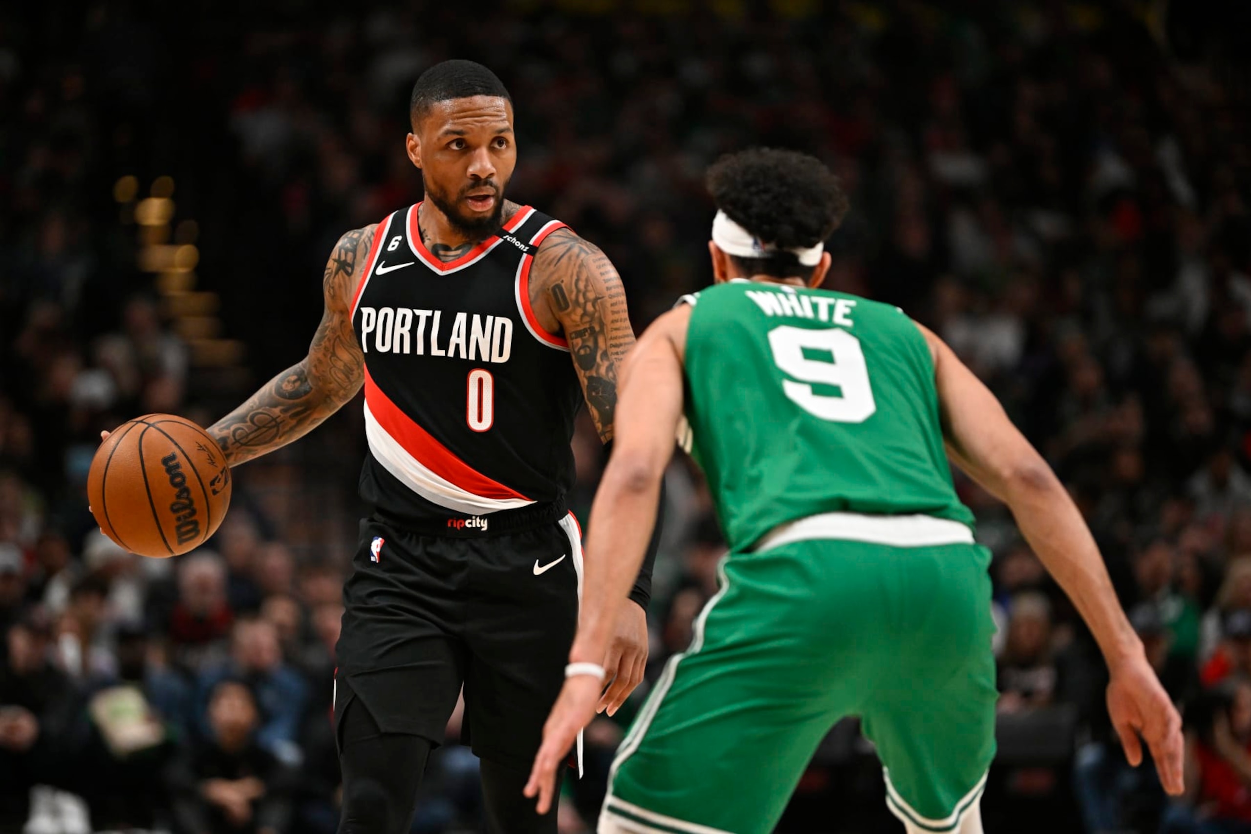 PORTLAND, OREGON - MARCH 17: Damian Lillard #0 of the Portland Trail Blazers dribbles against Derrick White #9 of the Boston Celtics during the second quarter at the Moda Center on March 17, 2023 in Portland, Oregon. NOTE TO USER: User expressly acknowledges and agrees that, by downloading and or using this photograph, User is consenting to the terms and conditions of the Getty Images License Agreement. (Photo by Alika Jenner/Getty Images)