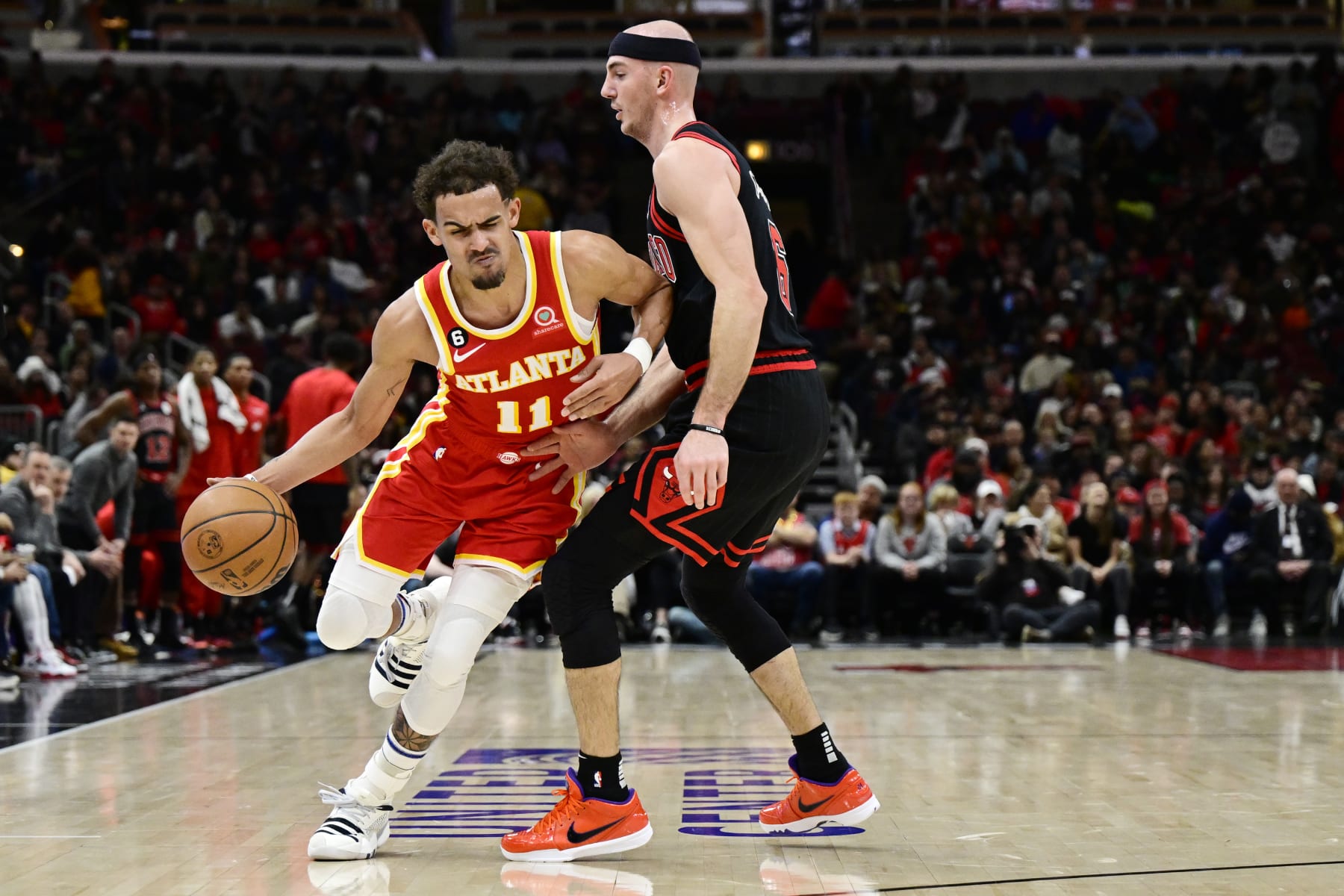 CHICAGO, ILLINOIS - JANUARY 23: Trae Young #11 of the Atlanta Hawks is fouled by Alex Caruso #6 of the Chicago Bulls in the first half at United Center on January 23, 2023 in Chicago, Illinois.  NOTE TO USER: User expressly acknowledges and agrees that, by downloading and or using this photograph, User is consenting to the terms and conditions of the Getty Images License Agreement (Photo by Quinn Harris/Getty Images)