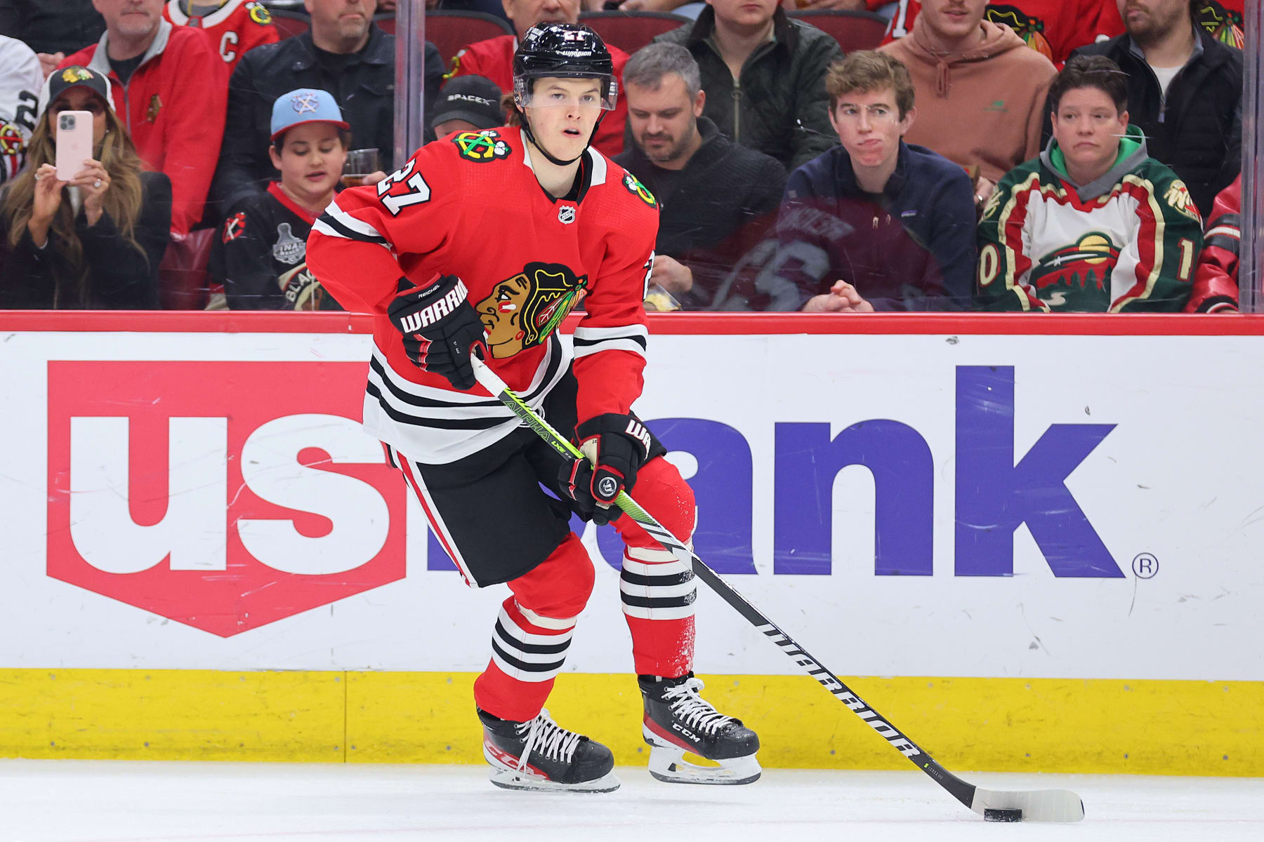 CHICAGO, ILLINOIS - MARCH 26: Lukas Reichel #27 of the Chicago Blackhawks skates with the puck against the Vancouver Canucks during the third period at United Center on March 26, 2023 in Chicago, Illinois. (Photo by Michael Reaves/Getty Images)