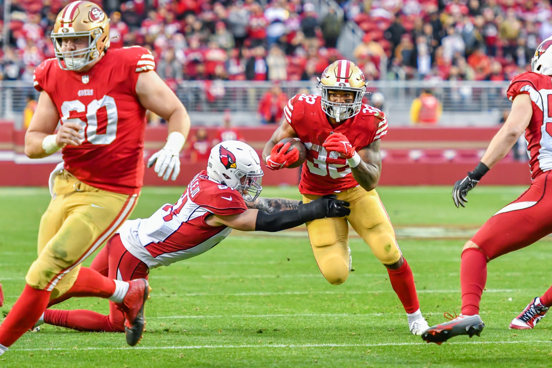 SANTA CLARA, CA - JANUARY 08: San Francisco 49ers running back Tyrion Davis-Price (32) runs through a tackle by Arizona Cardinals linebacker Tanner Vallejo (51) during the Week 18 game between the Arizona Cardinals and the San Francisco 49ers on Sunday, January 8, 2023 at Levi's Stadium in Santa Clara, California. (Photo by Douglas Stringer/Icon Sportswire via Getty Images)