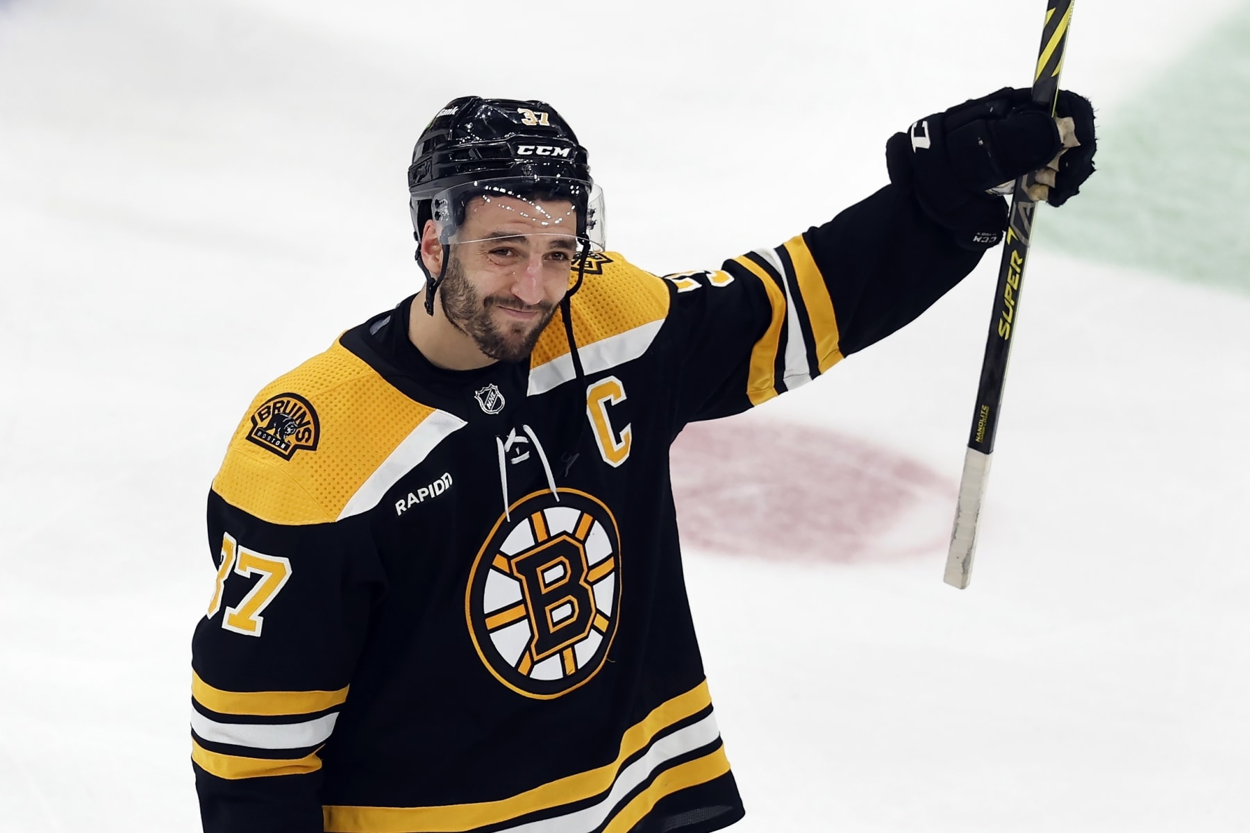 Boston Bruins' Patrice Bergeron raises his stick to the fans after losing to the Florida Panthers in overtime during Game 7 of an NHL hockey Stanley Cup first-round playoff series, Sunday, April 30, 2023, in Boston. (AP Photo/Michael Dwyer)