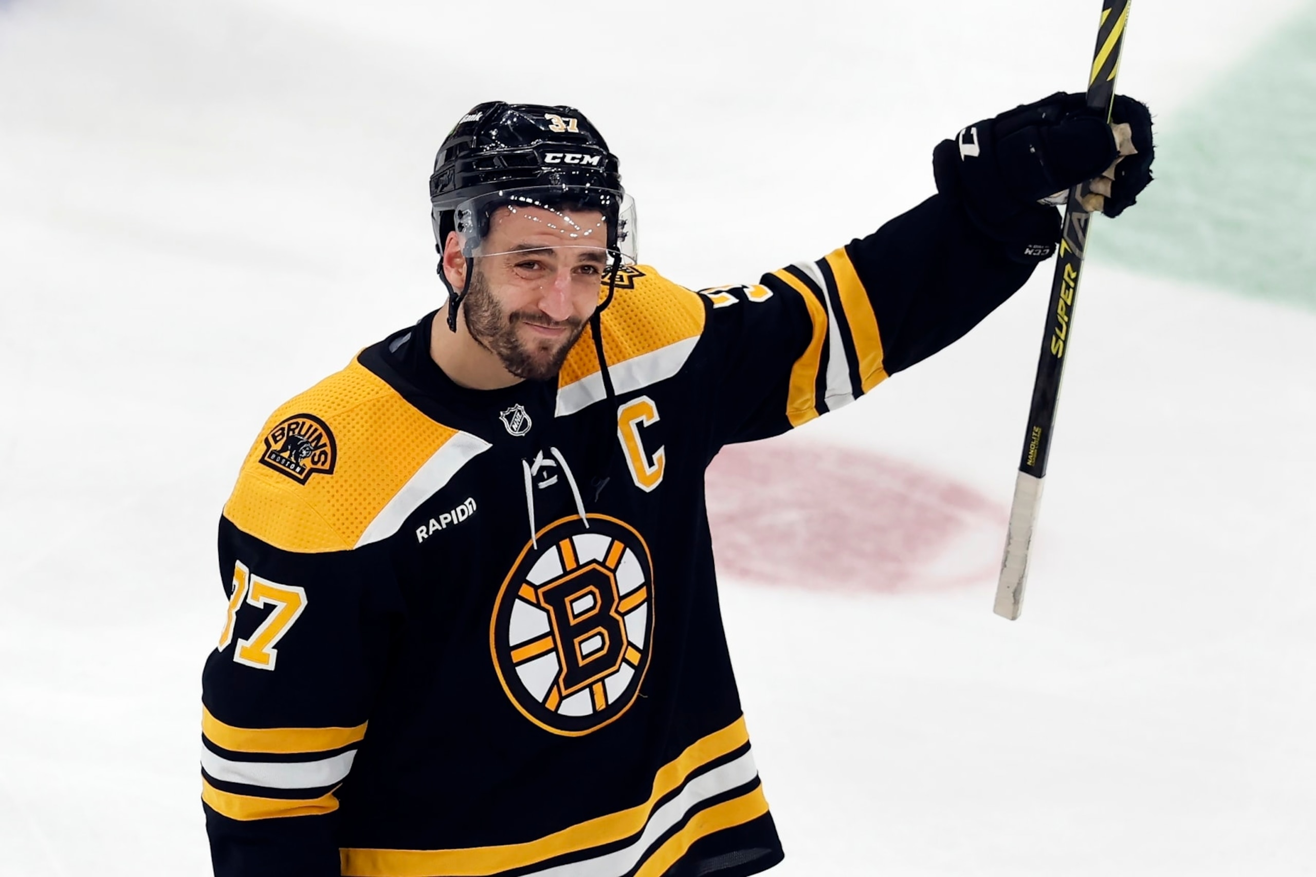 Boston Bruins' Patrice Bergeron raises his stick to the fans after losing to the Florida Panthers in overtime during Game 7 of an NHL hockey Stanley Cup first-round playoff series, Sunday, April 30, 2023, in Boston. (AP Photo/Michael Dwyer)