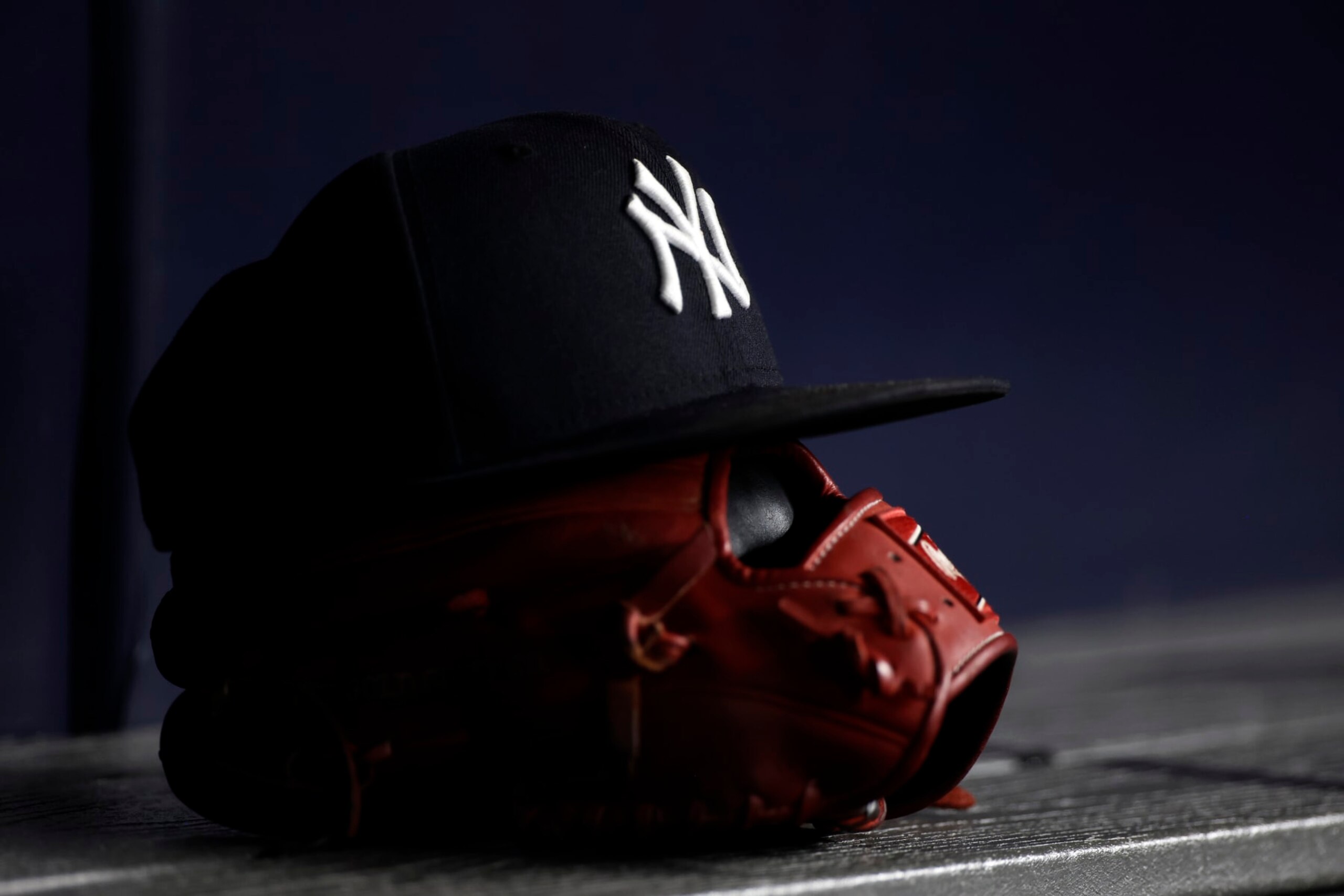 NEW YORK, NY - JUNE 6: A New York Yankees baseball hat sits on top of a glove in the Yankee dugout against the Boston Red Sox during the eighth inning at Yankee Stadium on June 6, 2021 in the Bronx borough of New York City. (Photo by Adam Hunger/Getty Images)