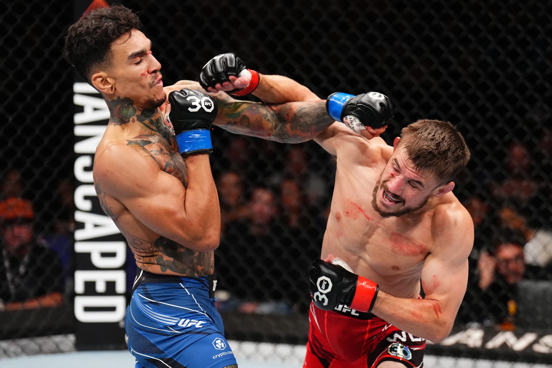 LONDON, ENGLAND - JULY 22: (R-) Nathaniel Wood of England punches Andre Fili in their featherweight fight during the UFC Fight Night at The O2 Arena on July 22, 2023 in London, England. (Photo by Chris Unger/Zuffa LLC via Getty Images)