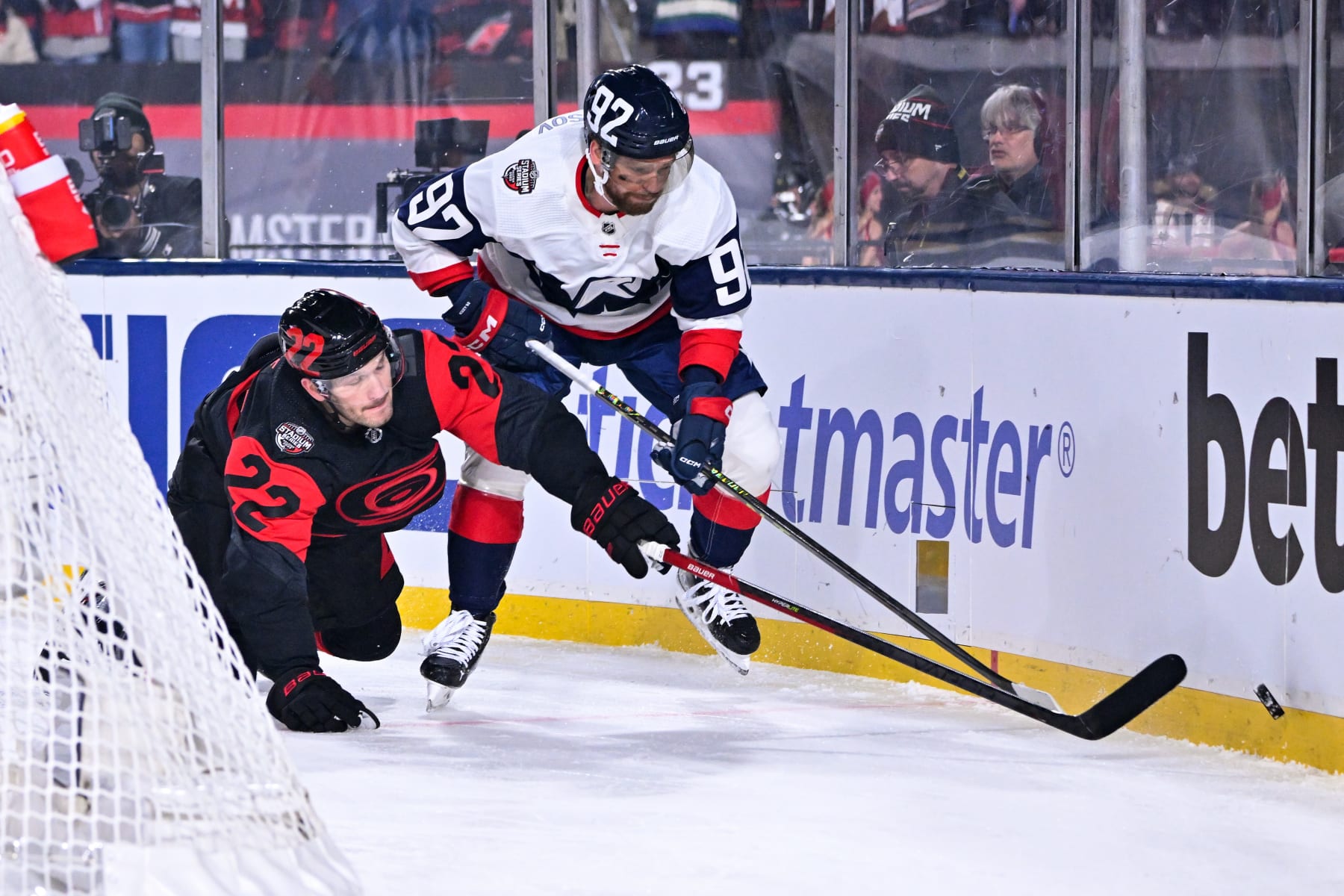 RALEIGH, NORTH CAROLINA - FEBRUARY 18: Brett Pesce #22 of the Carolina Hurricanes and Evgeny Kuznetsov #92 of the Washington Capitals compete for the puck during the second period in the 2023 Navy Federal Credit Union NHL Stadium Series at Carter-Finley Stadium on February 18, 2023 in Raleigh, North Carolina. (Photo by Grant Halverson/Getty Images)