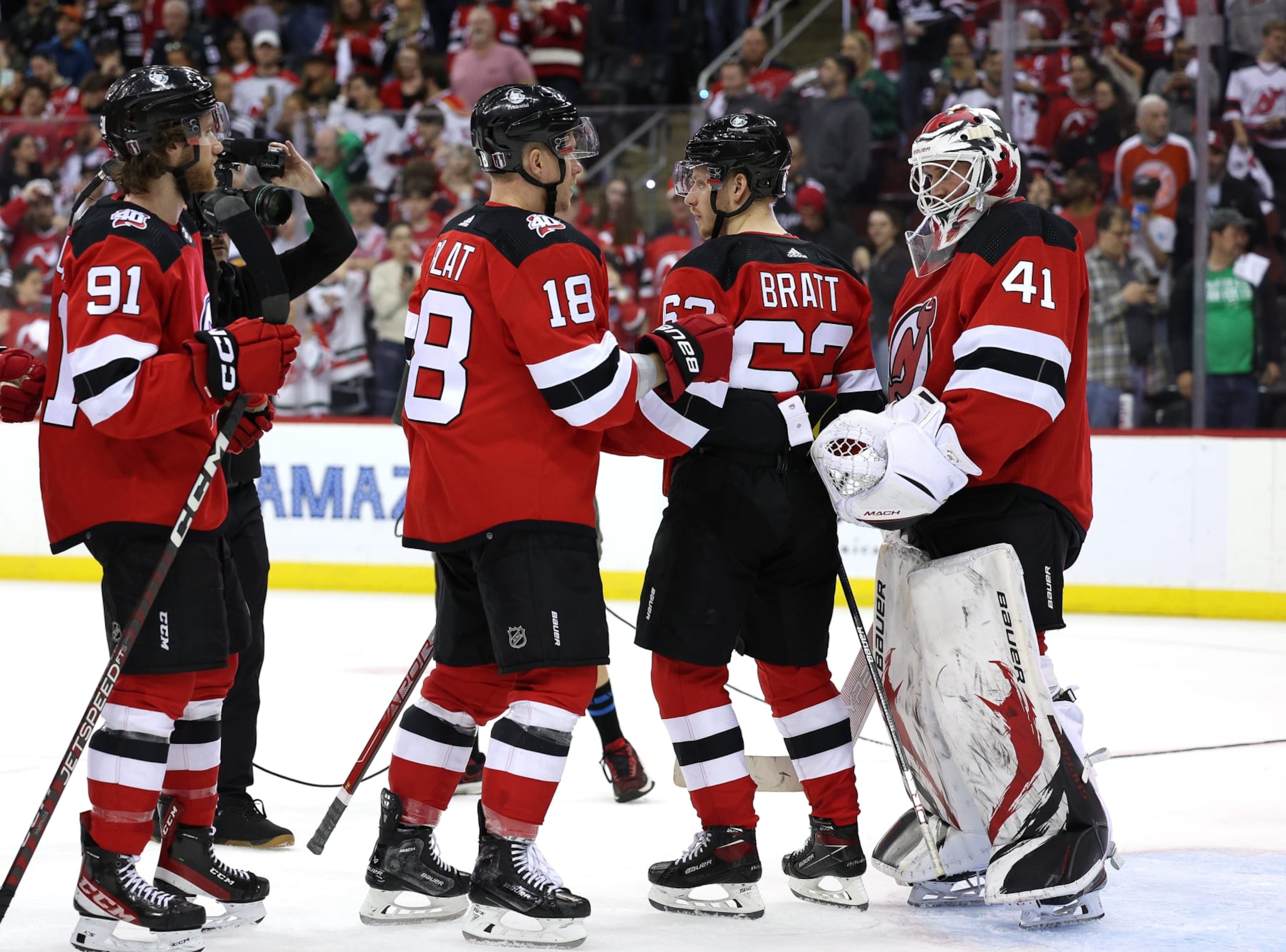 NEWARK, NEW JERSEY - MAY 07:  Vitek Vanecek #41 of the New Jersey Devils is congratulated by teammates Dawson Mercer #91,Ondrej Palat #18 and Jesper Bratt #63 after the win over the Carolina Hurricanes in Game Three of the Second Round of the 2023 Stanley Cup Playoffs at Prudential Center on May 07, 2023 in Newark, New Jersey. The New Jersey Devils defeated the Carolina Hurricanes 8-4. (Photo by Elsa/Getty Images)