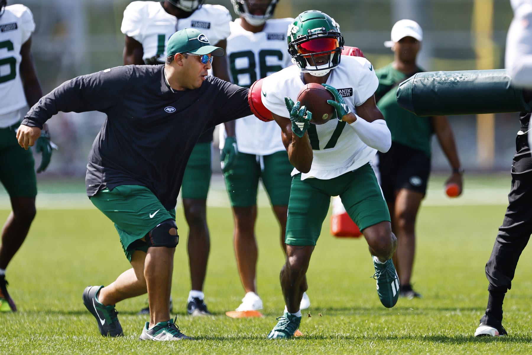FLORHAM PARK, NEW JERSEY - JULY 26: Wide receiver Garrett Wilson #17 of the New York Jets busts through two coaches after making a catch during training camp at Atlantic Health Jets Training Center on July 26, 2023 in Florham Park, New Jersey. (Photo by Rich Schultz/Getty Images)