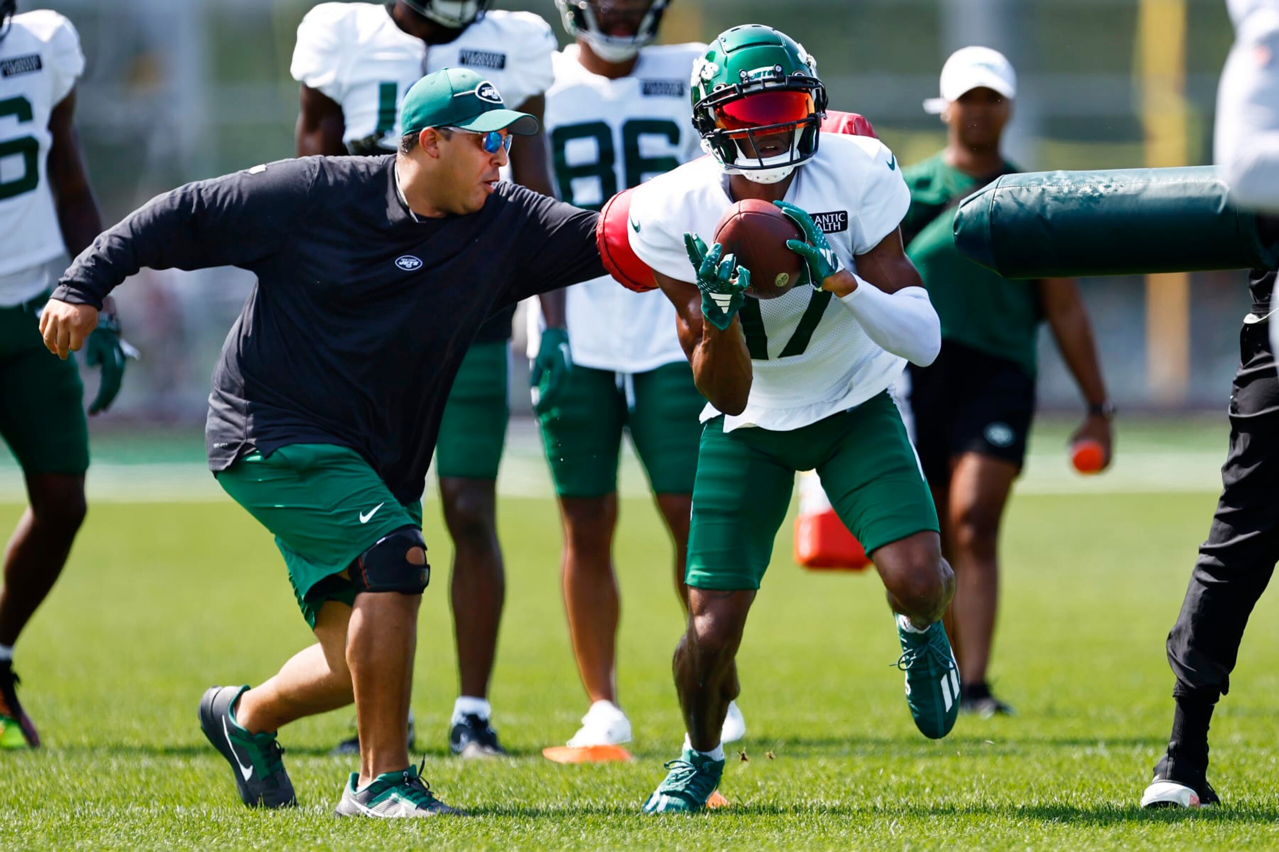 FLORHAM PARK, NEW JERSEY - JULY 26: Wide receiver Garrett Wilson #17 of the New York Jets busts through two coaches after making a catch during training camp at Atlantic Health Jets Training Center on July 26, 2023 in Florham Park, New Jersey. (Photo by Rich Schultz/Getty Images)
