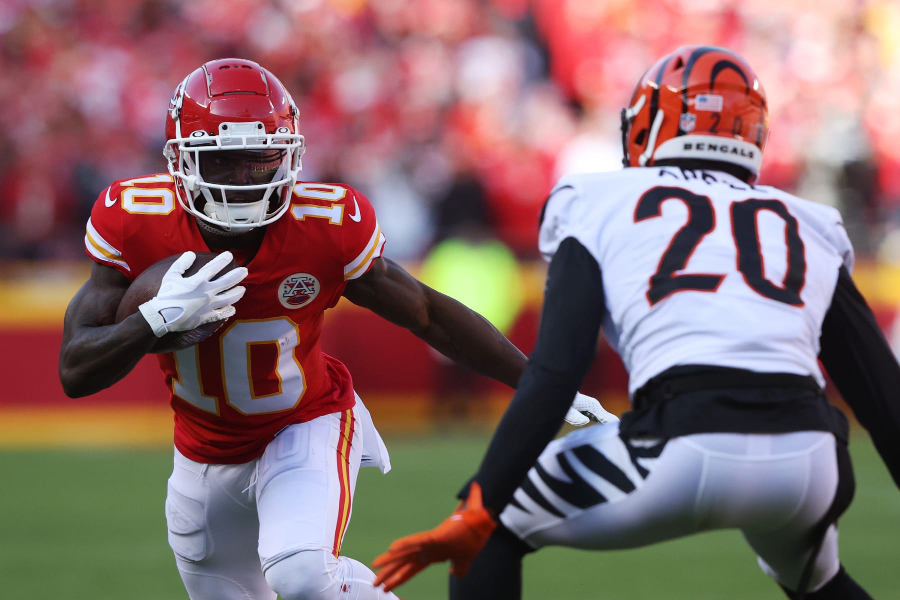 KANSAS CITY, MISSOURI - JANUARY 30: Tyreek Hill #10 of the Kansas City Chiefs carries the ball as Eli Apple #20 of the Cincinnati Bengals defends in the AFC Championship Game at Arrowhead Stadium on January 30, 2022 in Kansas City, Missouri. (Photo by Jamie Squire/Getty Images)