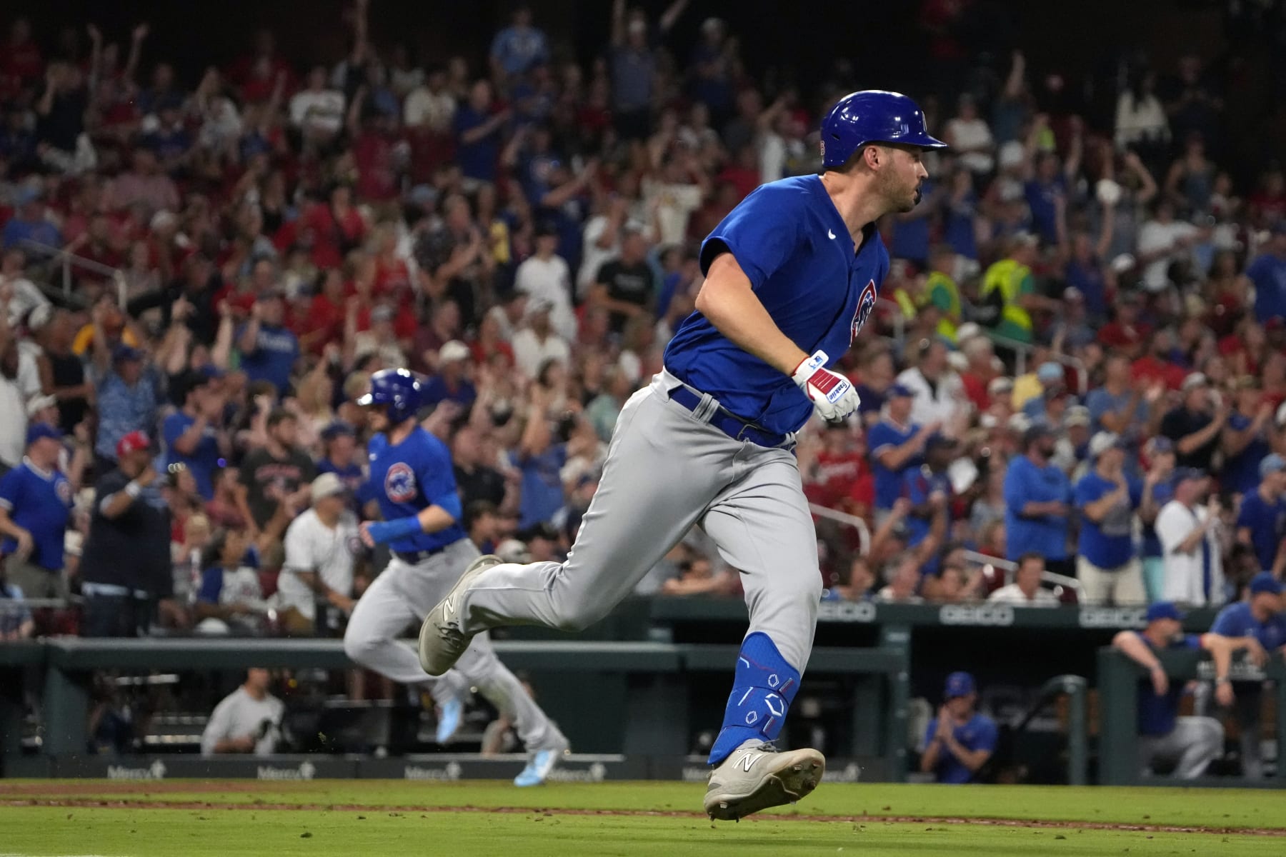 Chicago Cubs' Trey Mancini heads to first on an RBI single as Ian Happ, left, comes in to score during the sixth inning of a baseball game Friday, July 28, 2023, in St. Louis. (AP Photo/Jeff Roberson)
