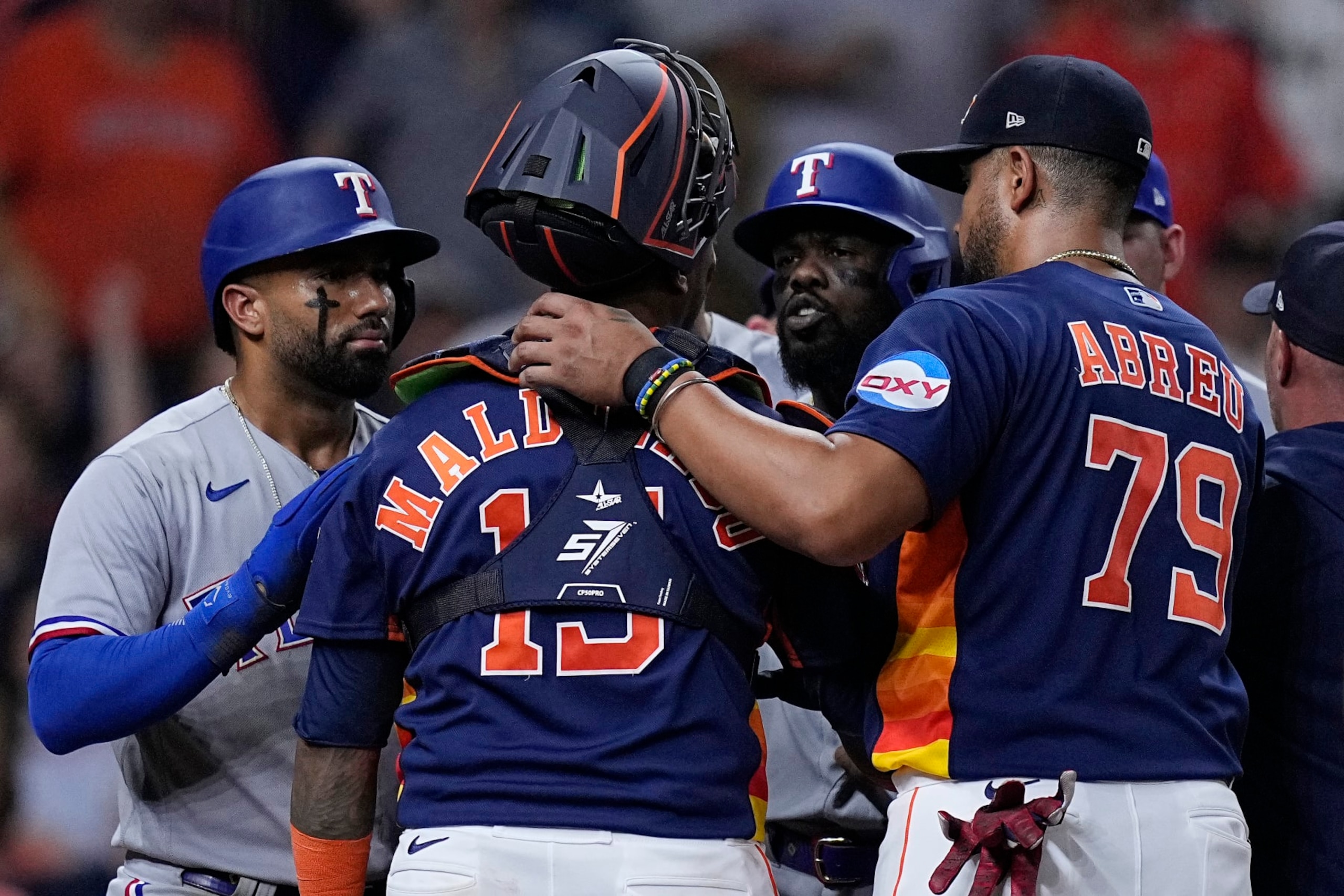 Houston Astros catcher Martin Maldonado and Texas Rangers' Adolis Garcia, third from left, argue as the benches clear following Garcia's grand slam during the fifth inning of a baseball game, Wednesday, July 26, 2023, in Houston. (AP Photo/Kevin M. Cox)