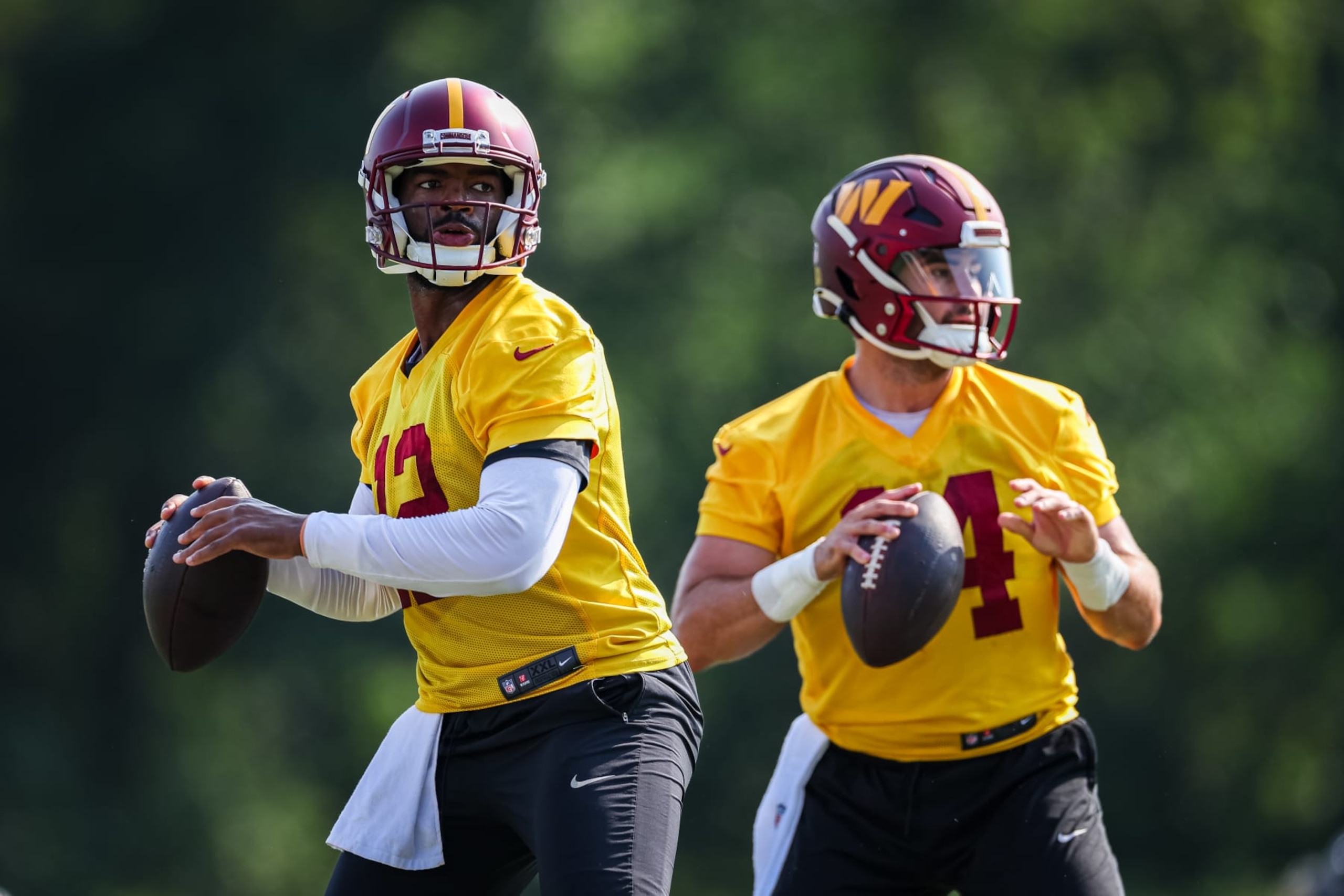 ASHBURN, VA - JULY 28: Quarterbacks Jacoby Brissett #12 and Sam Howell #14 of the Washington Commanders look to pass during training camp at OrthoVirginia Training Center on July 28, 2022 in Ashburn, Virginia. (Photo by Scott Taetsch/Getty Images)