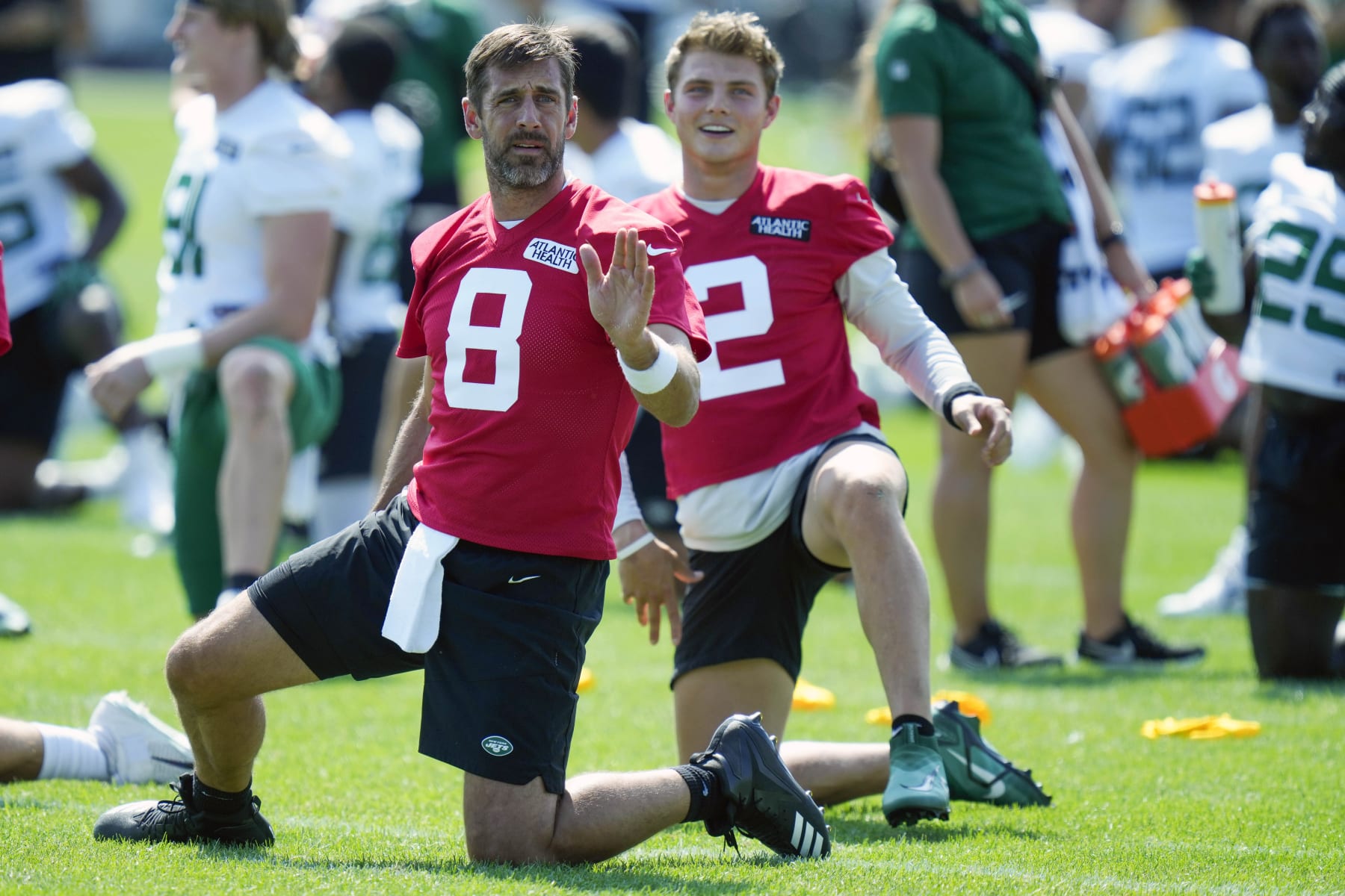New York Jets quarterbacks Aaron Rodgers, left, and Zach Wilson talk as they stretch at the NFL football team's training facility in Florham Park, N.J., Sunday, July 23, 2023. (AP Photo/Seth Wenig)