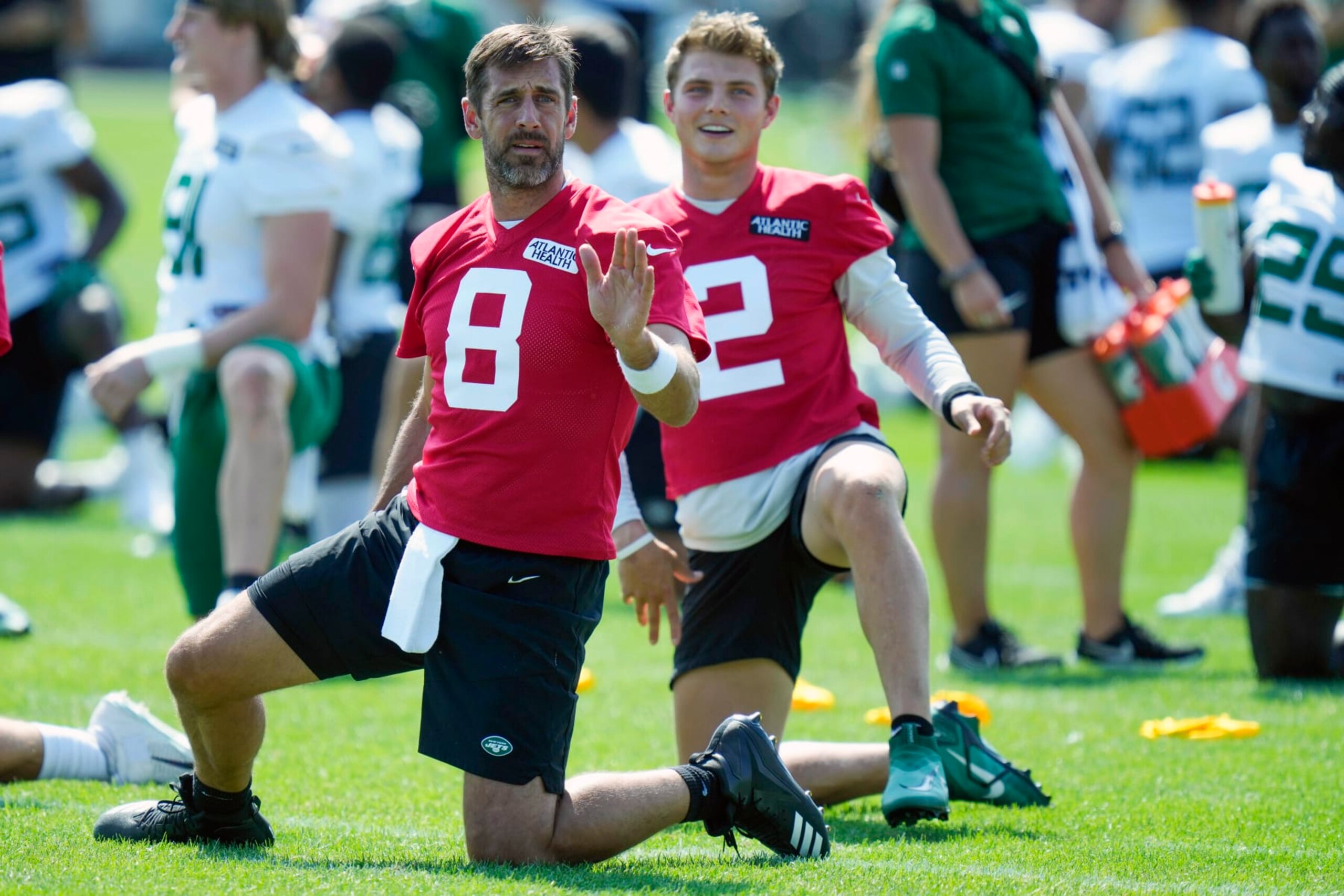 New York Jets quarterbacks Aaron Rodgers, left, and Zach Wilson talk as they stretch at the NFL football team's training facility in Florham Park, N.J., Sunday, July 23, 2023. (AP Photo/Seth Wenig)
