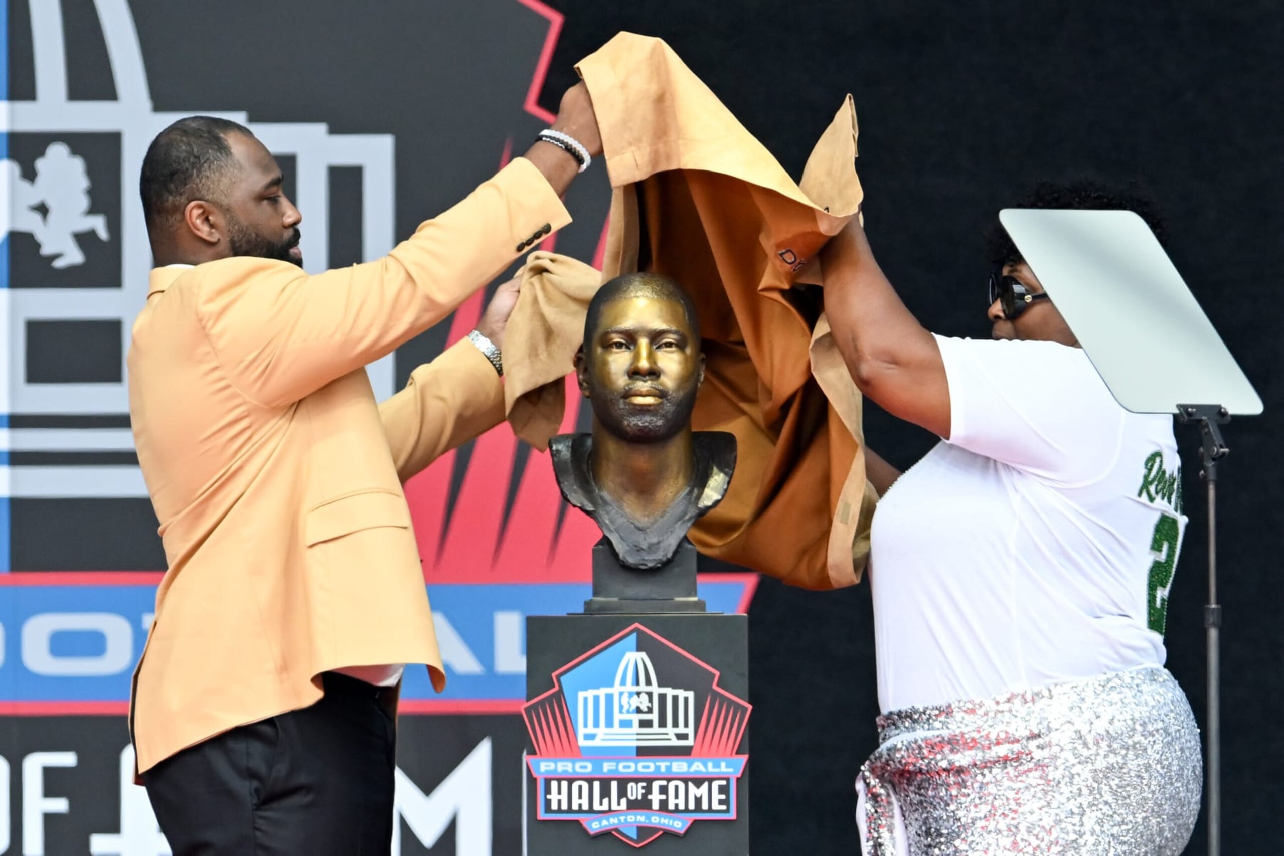 CANTON, OHIO - AUGUST 05: Darrelle Revis (L) and his present his mother Dianna Askew unveil Revis' bronze bust during the 2023 Pro Football Hall of Fame Enshrinement Ceremony at Tom Benson Hall Of Fame Stadium on August 05, 2023 in Canton, Ohio. (Photo by Nick Cammett/Getty Images)