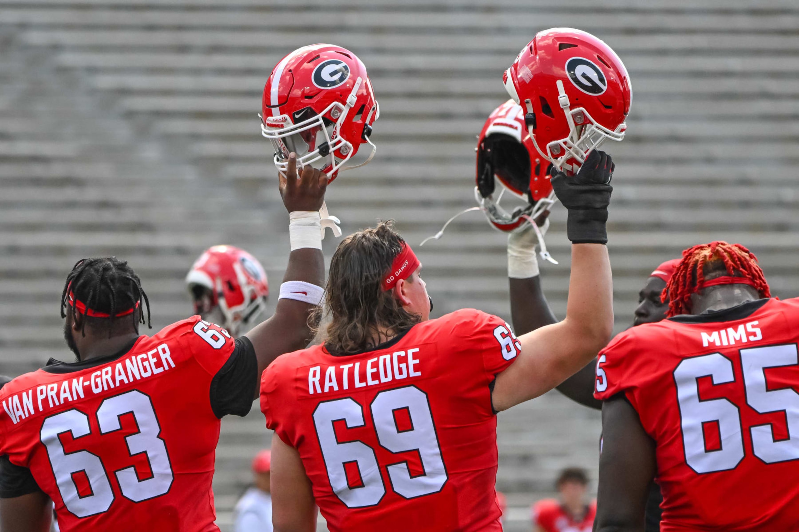ATHENS, GA - APRIL 15: Georgia Bulldogs Jr. OL Sedrick Van Pran (63), Jr. OL Tate Ratledge (69), and Jr. OL Amarius Mims (65) honor teammate Devin Willock and Recruiting Coordinator Chandler LeCroy, who were killed in a car accident in January, during the G-Day Red and Black Spring Game on April 15, 2023, at Sanford Stadium in Athens, GA. (Photo by John Adams/Icon Sportswire via Getty Images)