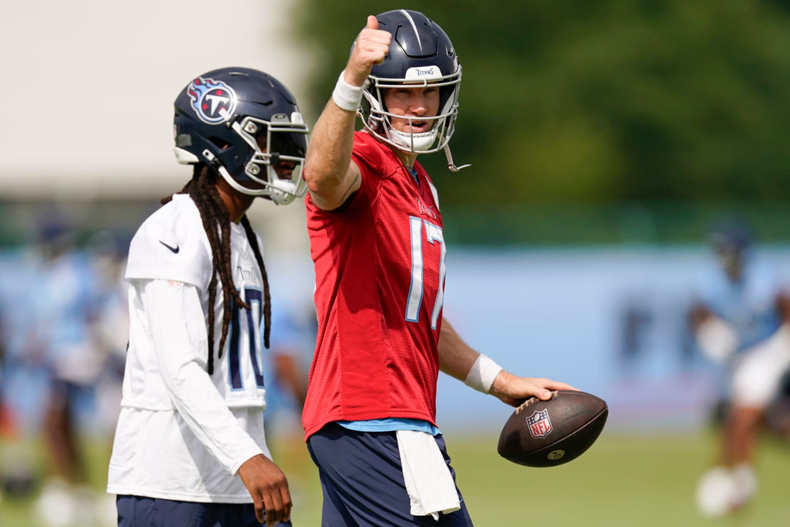 Tennessee Titans quarterback Ryan Tannehill, right, gives a thumbs up as he walks with wide receiver DeAndre Hopkins during an NFL football training camp practice Wednesday, July 26, 2023, in Nashville, Tenn. (AP Photo/George Walker IV)
